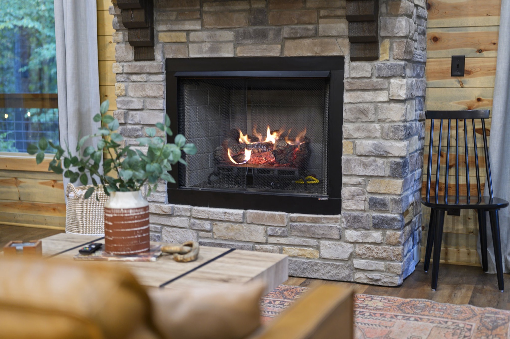 Curl up by the warmth of your own stone fireplace, where rustic charm meets modern comfort in this cozy living space.