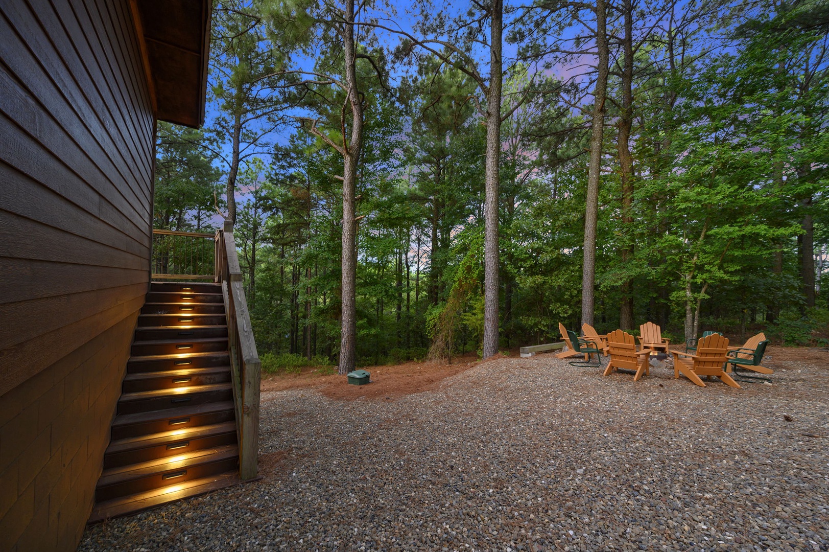The property features a secluded outdoor fire pit area nestled among tall pines, offering a peaceful retreat for evening gatherings under the stars.