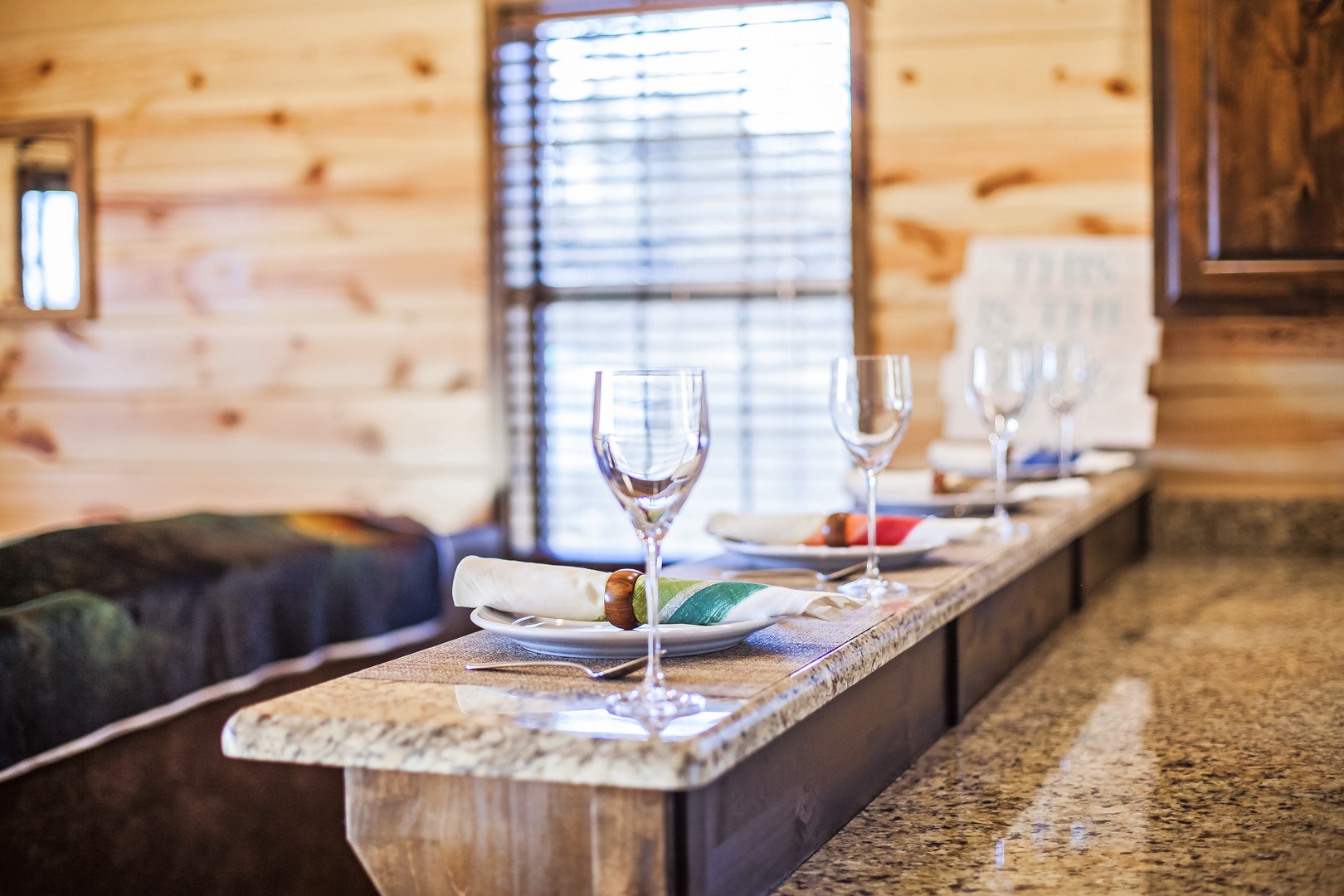 Your elegant dining counter awaits, where wine glasses catch the light streaming through windows in this cozy retreat.