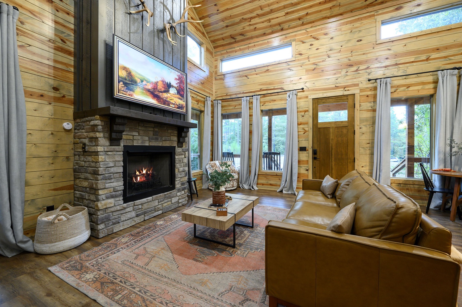 Your cozy retreat features soaring wood-paneled ceilings, a stone fireplace that crackles with warmth, and a buttery leather sofa where you'll sink in after a day exploring nature just outside your door.
