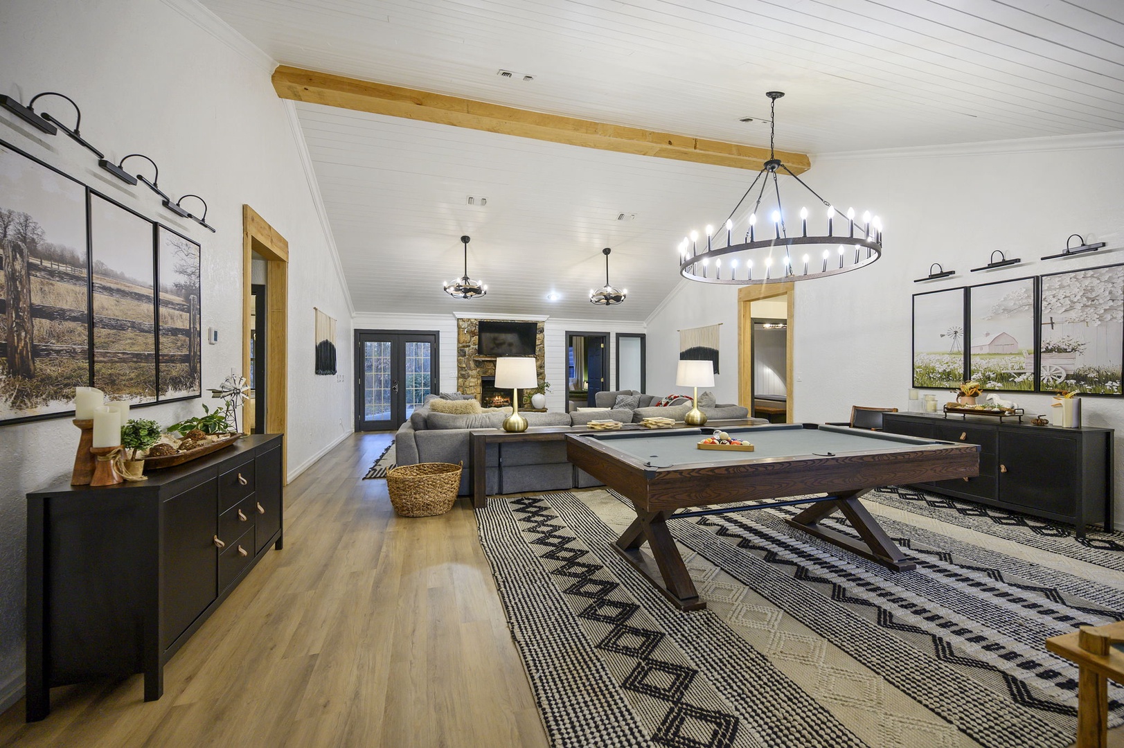 Step into your game room where rustic beams meet modern comfort—challenge friends to pool beneath elegant lighting.