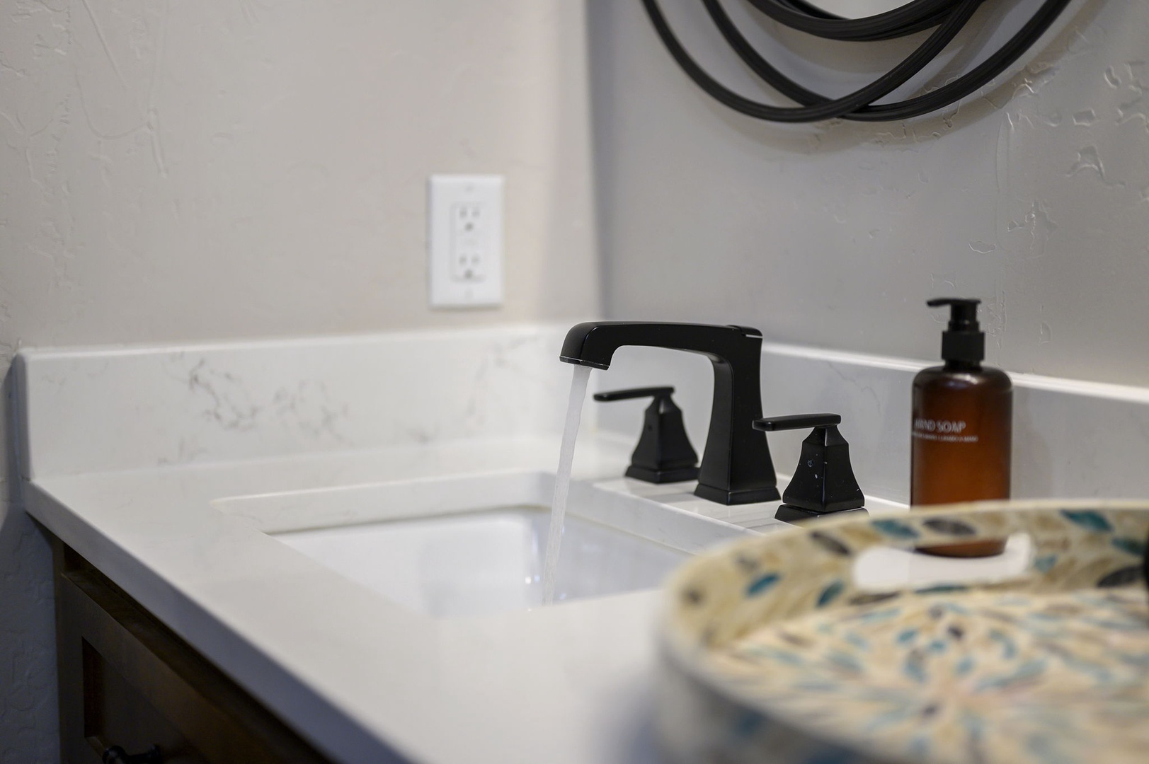 Freshen up in your sleek bathroom featuring modern fixtures, marble countertops, and quality hand soap to elevate your daily routine.