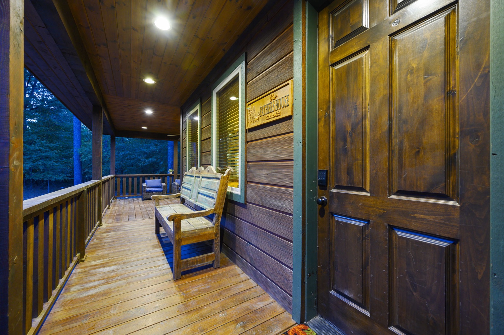 A peaceful, covered porch welcomes your arrival with rustic wooden accents and soft evening lighting. Settle onto the bench and let the surrounding forest set the tone for your getaway.