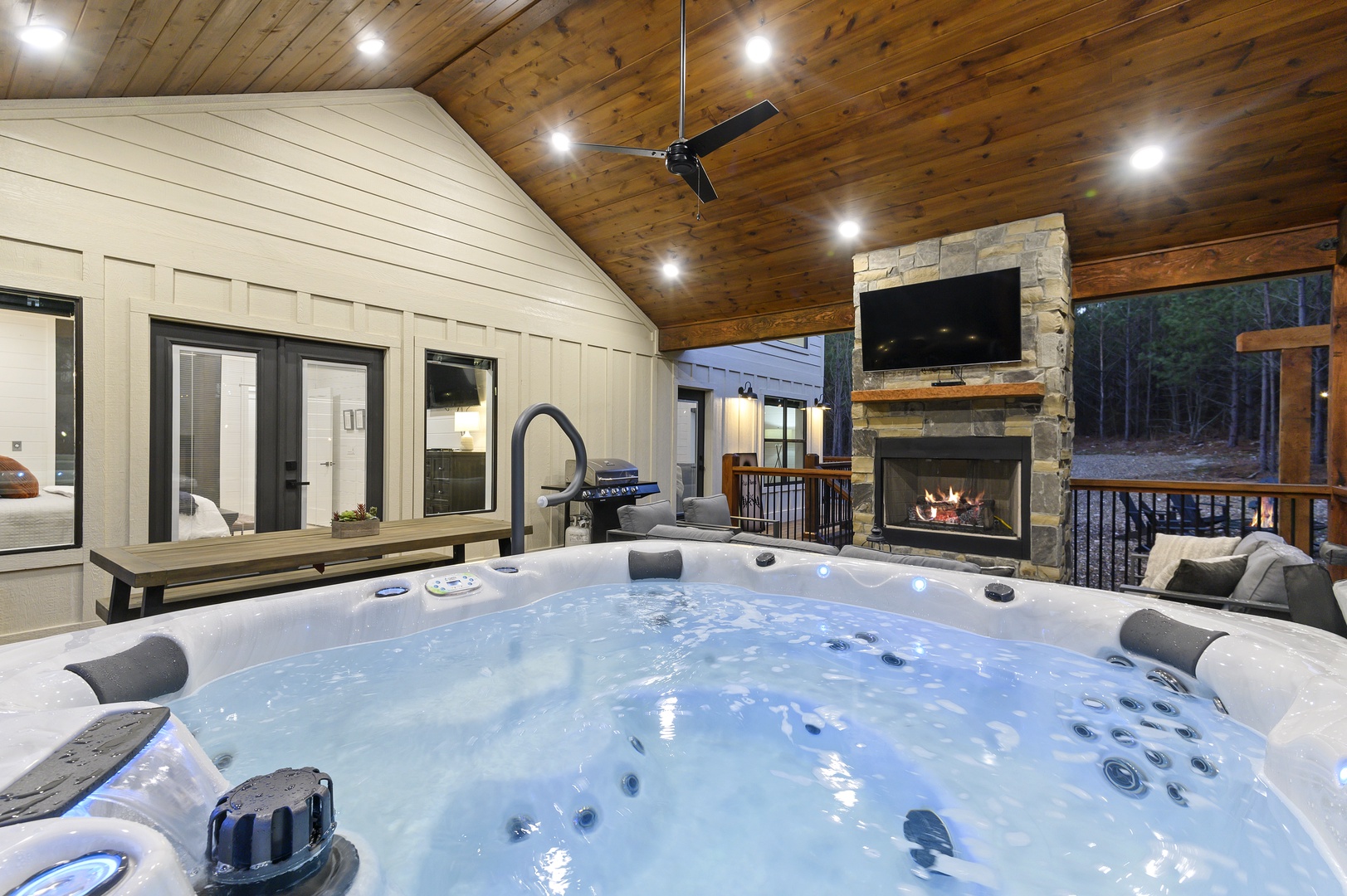 Sink into your private hot tub under soaring wood ceilings while the stone fireplace crackles nearby, creating the perfect mountain retreat atmosphere.