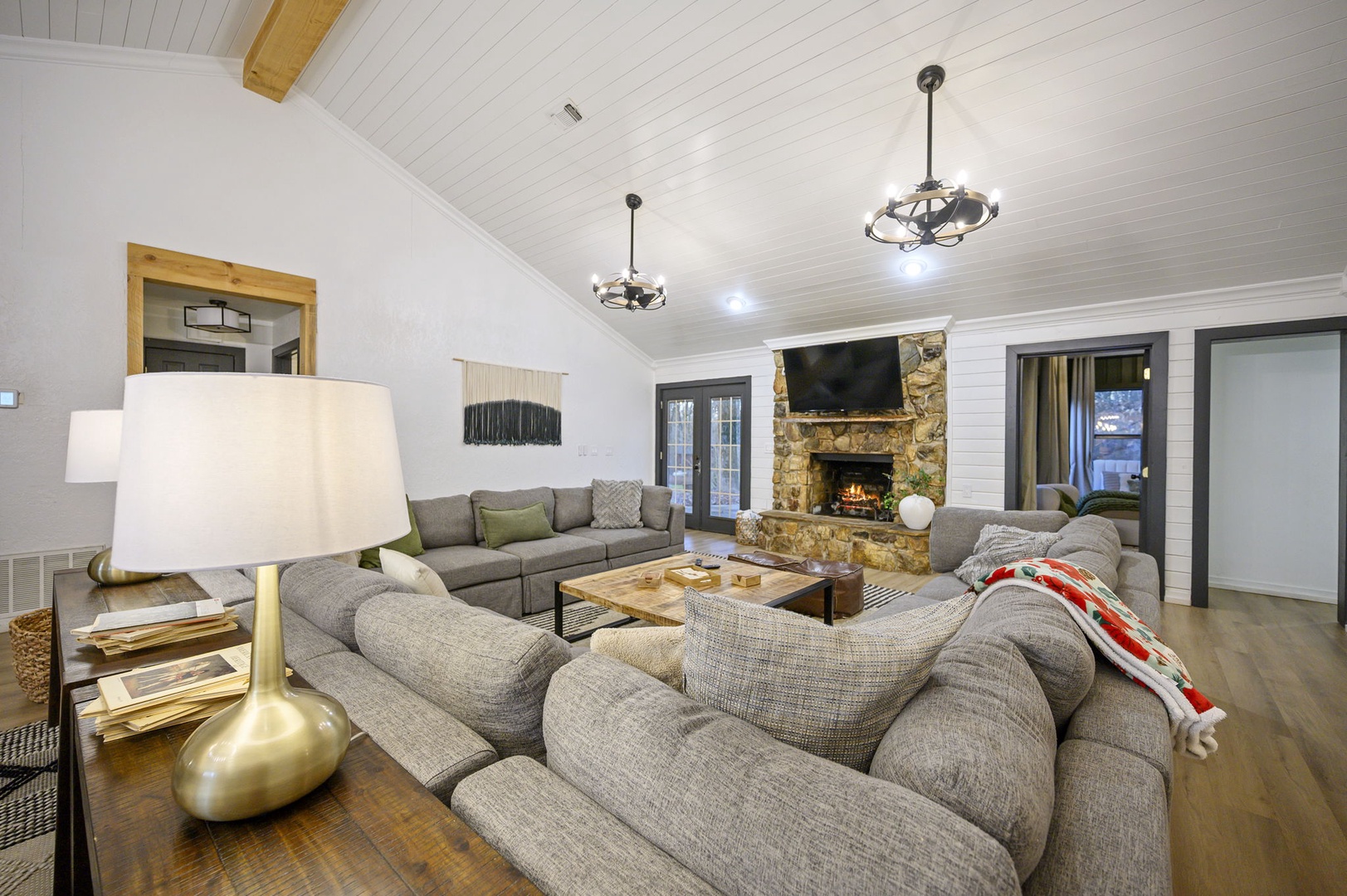 Sink into plush sofas by the crackling fireplace while golden pendant lights create perfect ambiance for your evening relaxation.