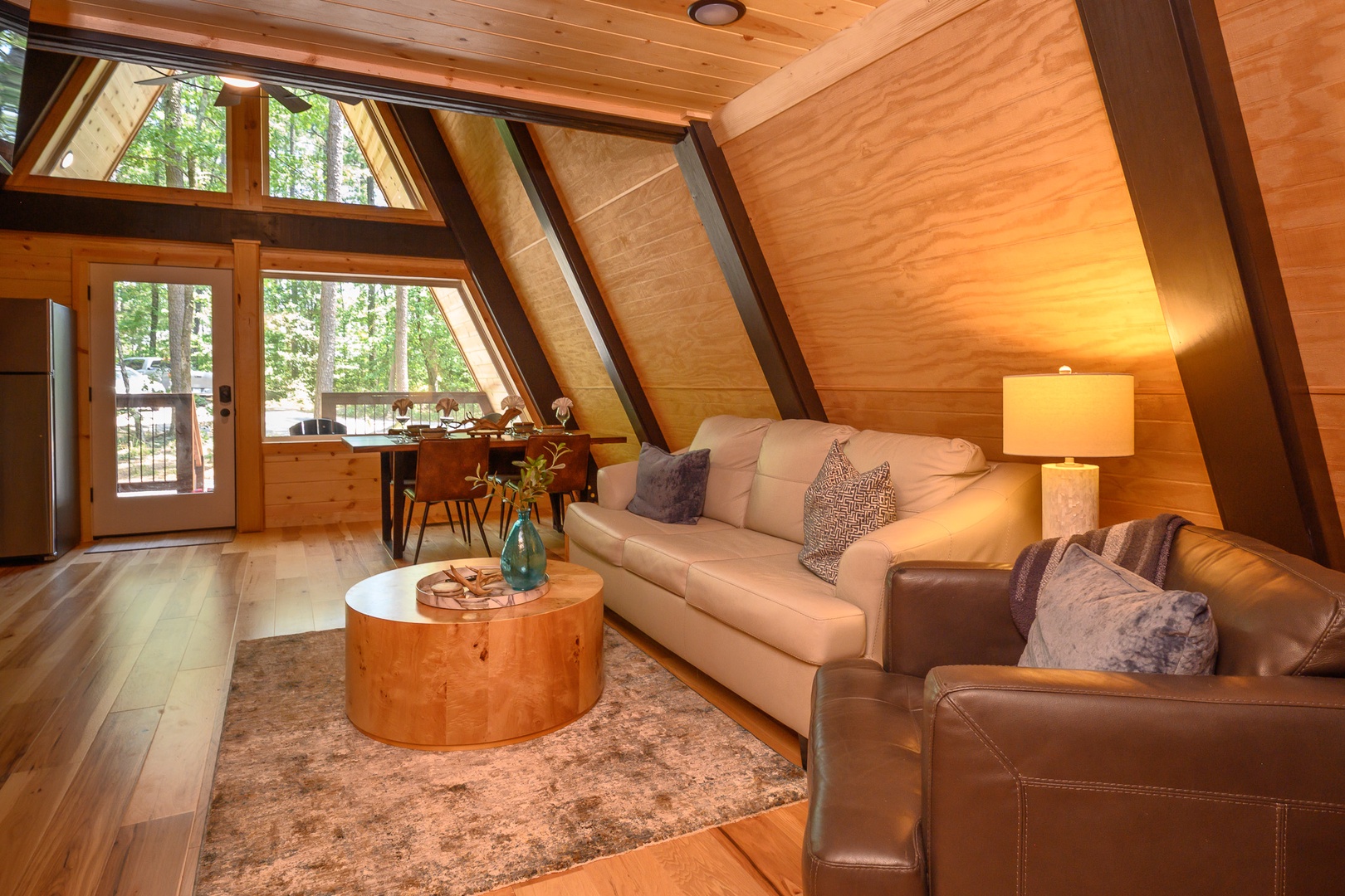 Sink into plush seating beneath soaring wood-paneled ceilings and let natural light pour through the windows. Your cozy A-frame retreat offers a seamless blend of modern comfort and rustic charm, perfect for unwinding after a day of adventure.