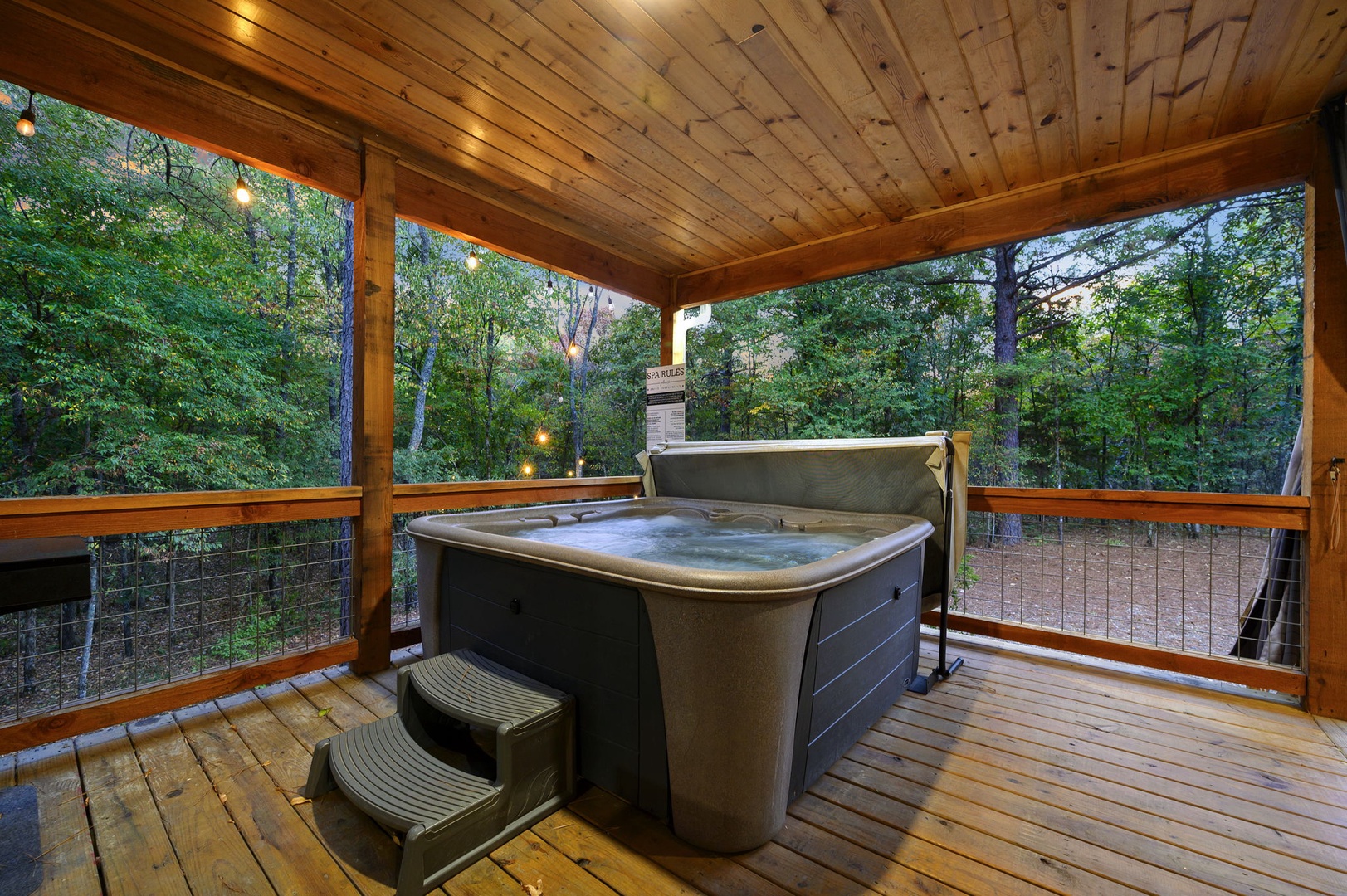 Slip into your private hot tub on the covered deck and let the forest views melt away your stress as the evening lights twinkle above.