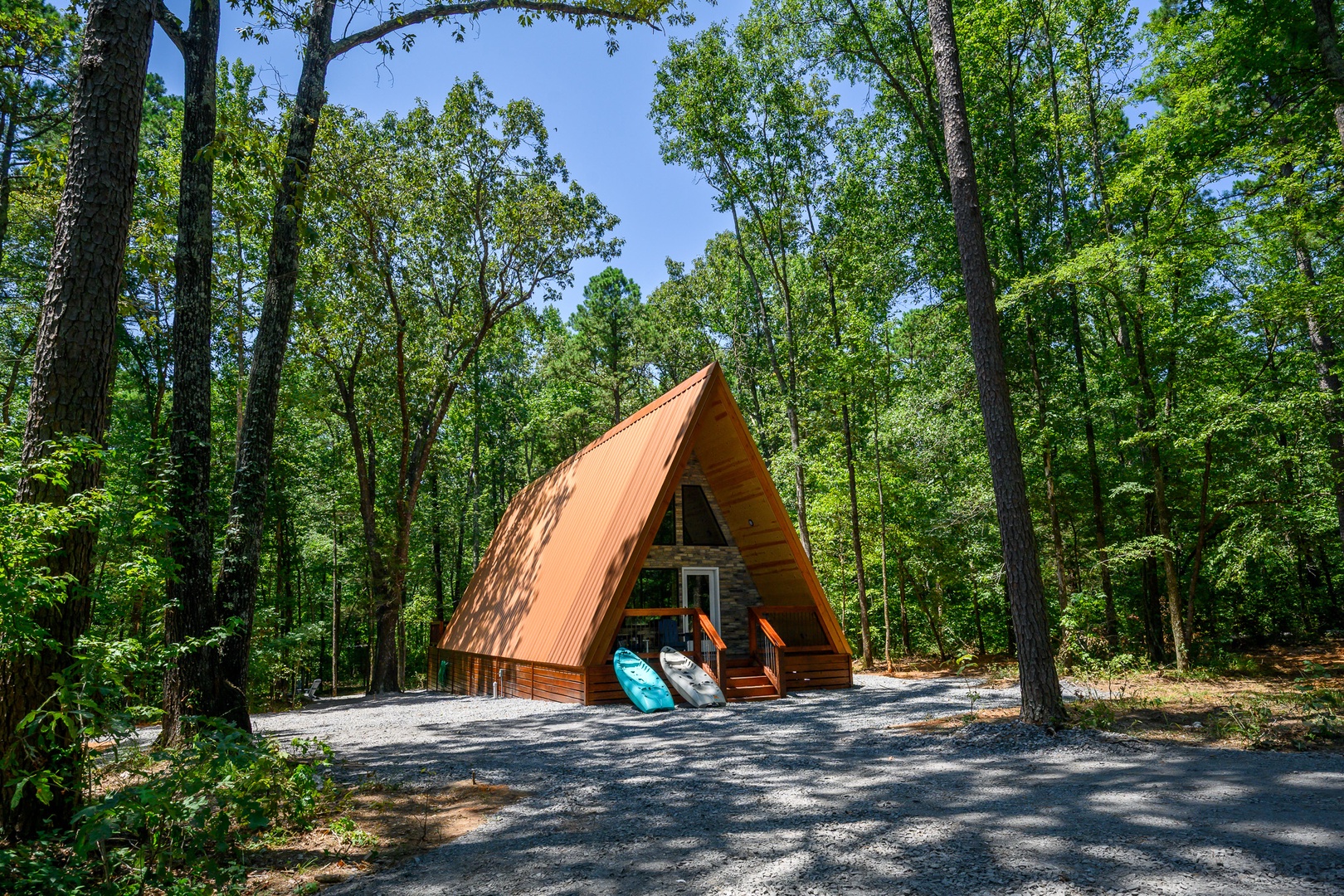 A charming A-frame cabin tucked into a peaceful forest setting, surrounded by towering trees and natural beauty for a secluded retreat.