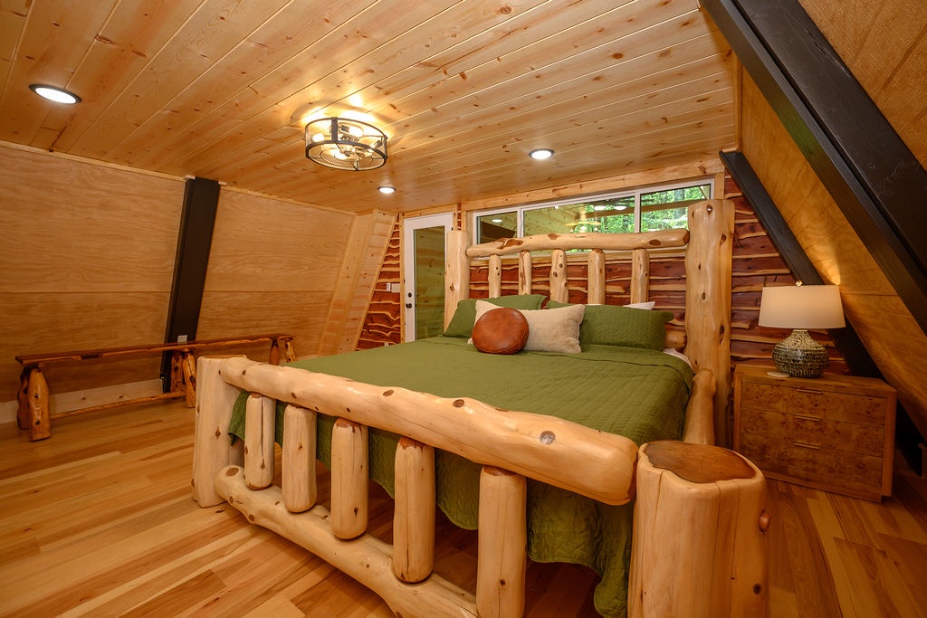 Your rustic retreat awaits with handcrafted log furnishings, warm wood tones throughout, and peaceful forest views framed by the windows—perfect for resting after a day of mountain adventures.
