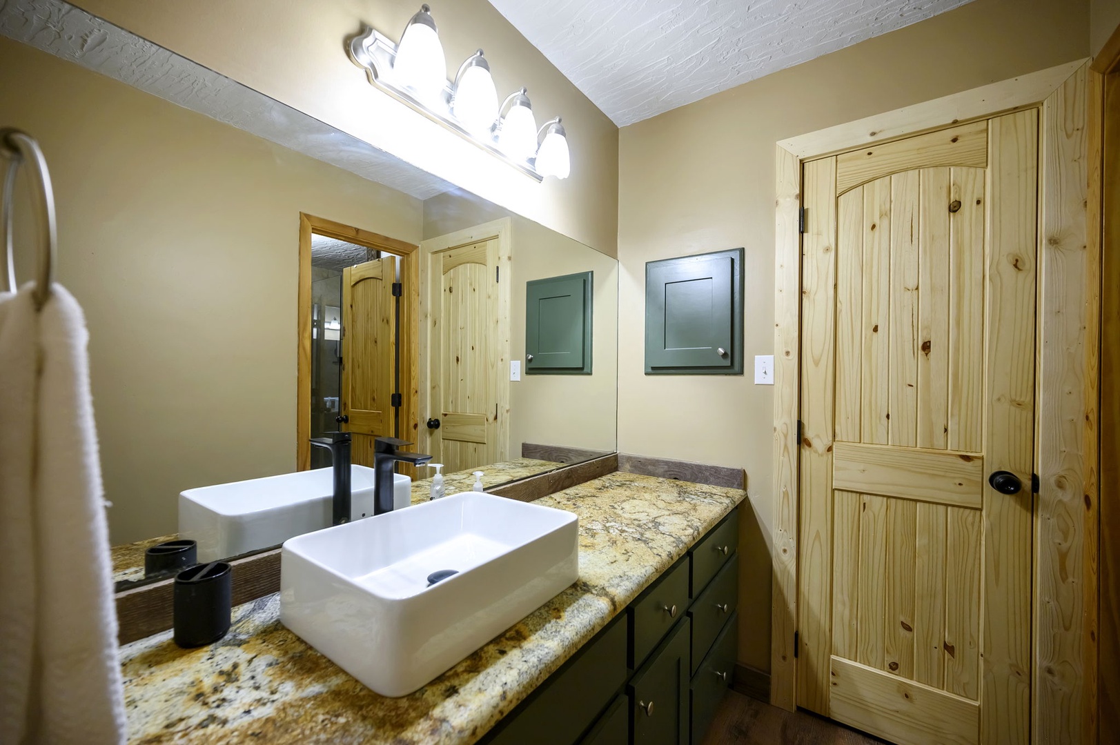 Your rustic bathroom features granite countertops, dual vessel sinks, and warm wood accents that create a cozy mountain retreat atmosphere.