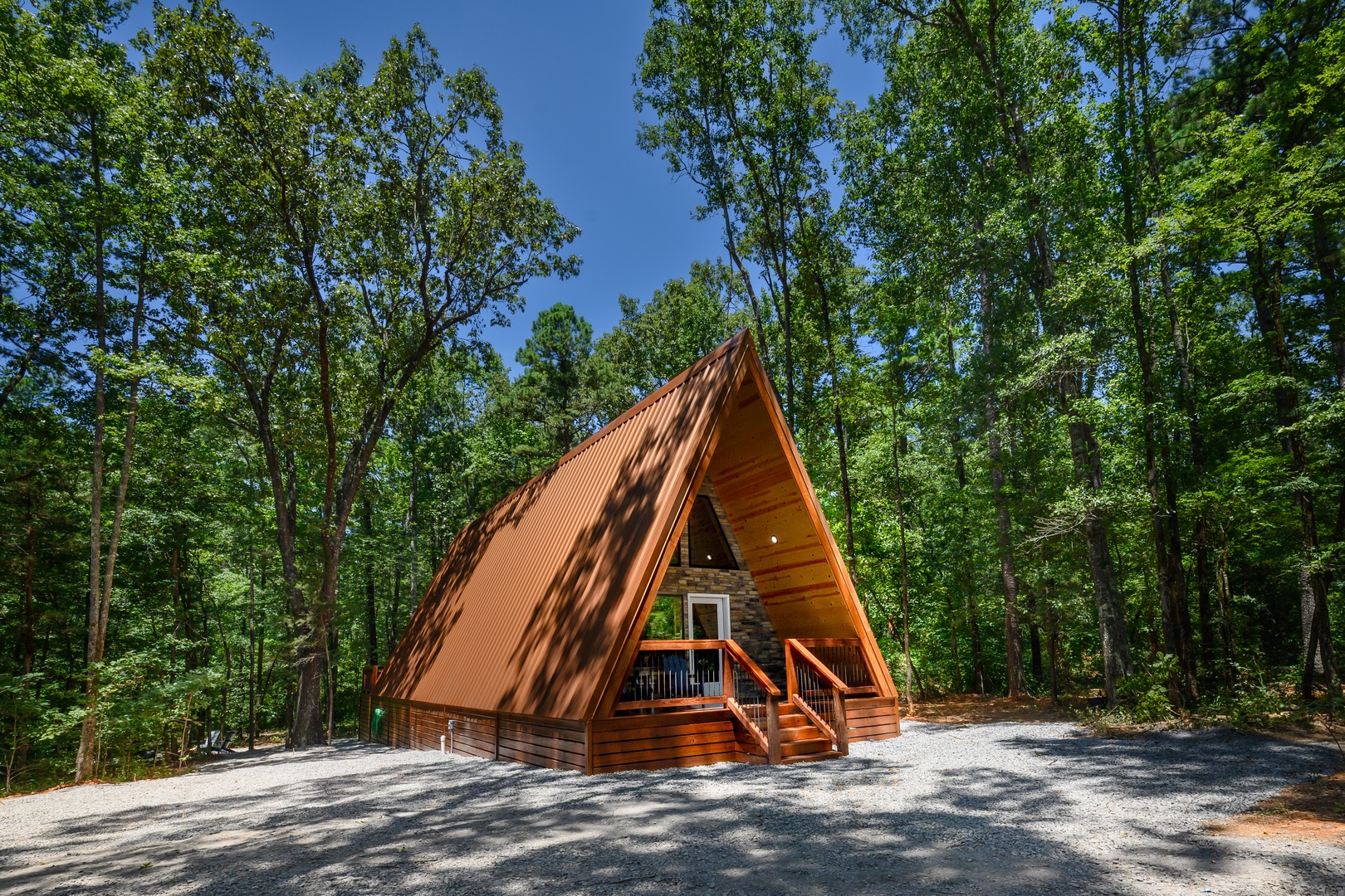 A-frame cabin tucked into lush wooded surroundings, offering a peaceful retreat among towering trees and natural beauty.
