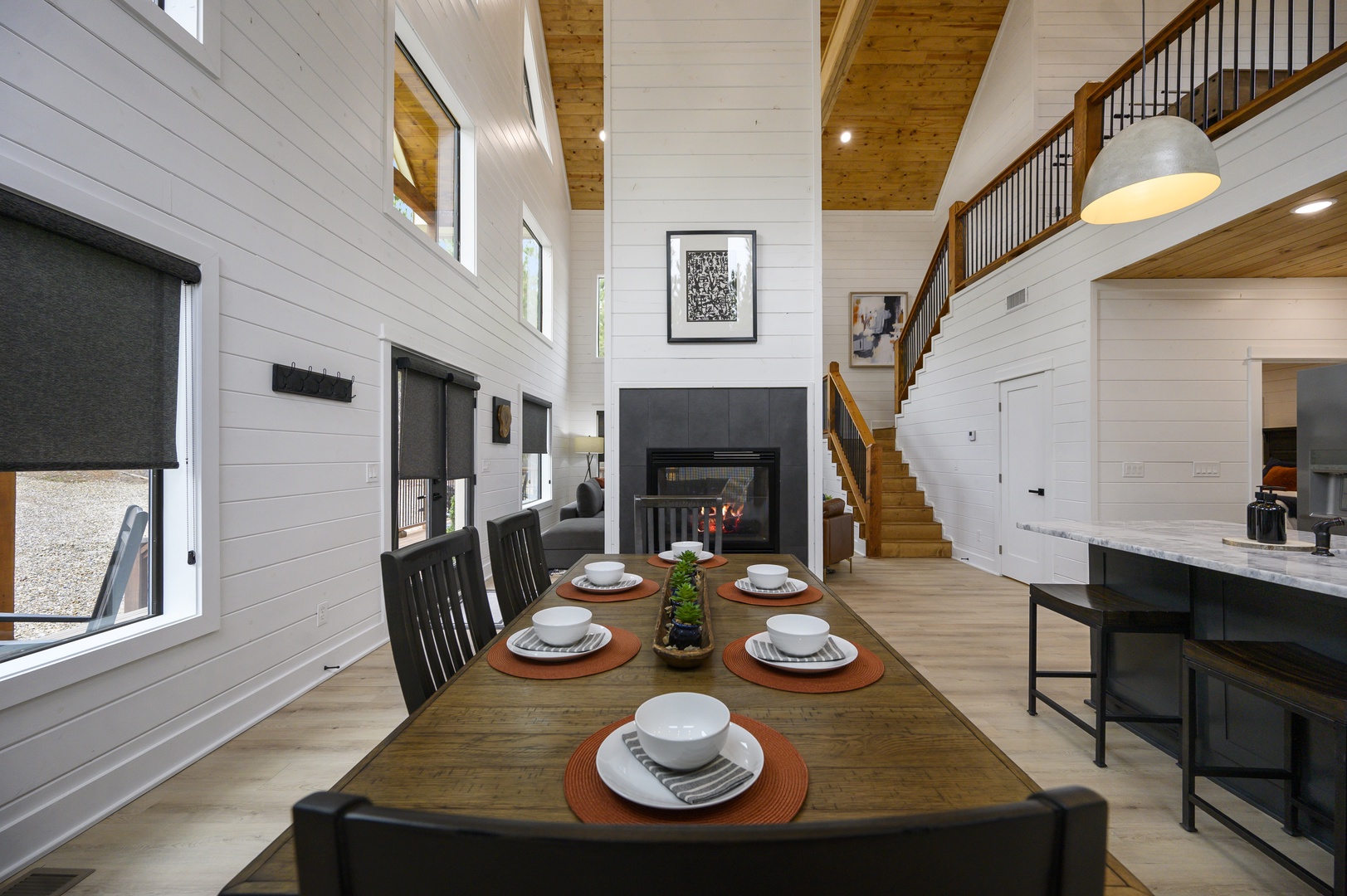 Gather around your rustic dining table while the fireplace crackles, creating perfect moments in this soaring open-concept space.