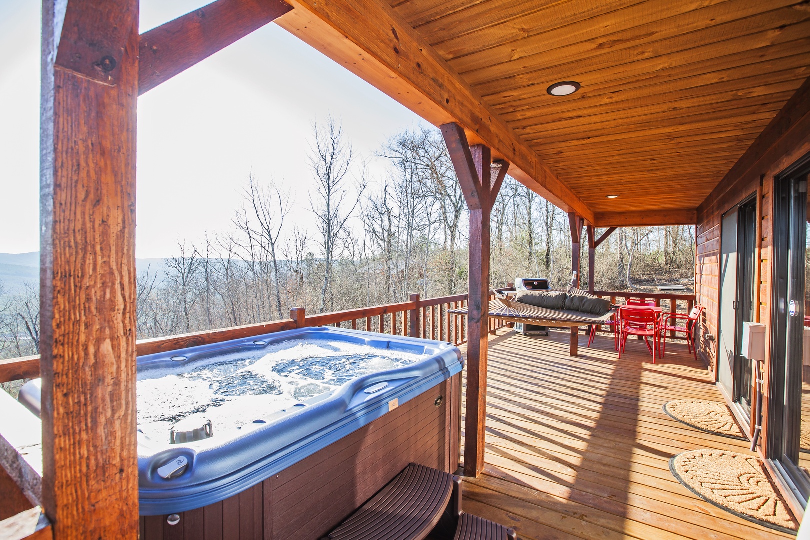 Soak in your private hot tub while savoring mountain views from this spacious wooden deck, complete with outdoor dining.