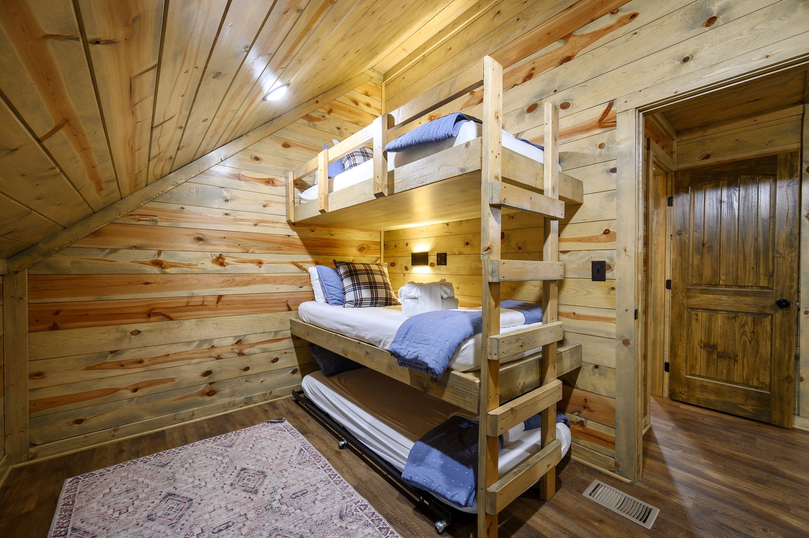 Your cozy sleeping nook features warm wood-paneled walls and a sturdy bunk bed, perfect for families or friends sharing mountain memories together.