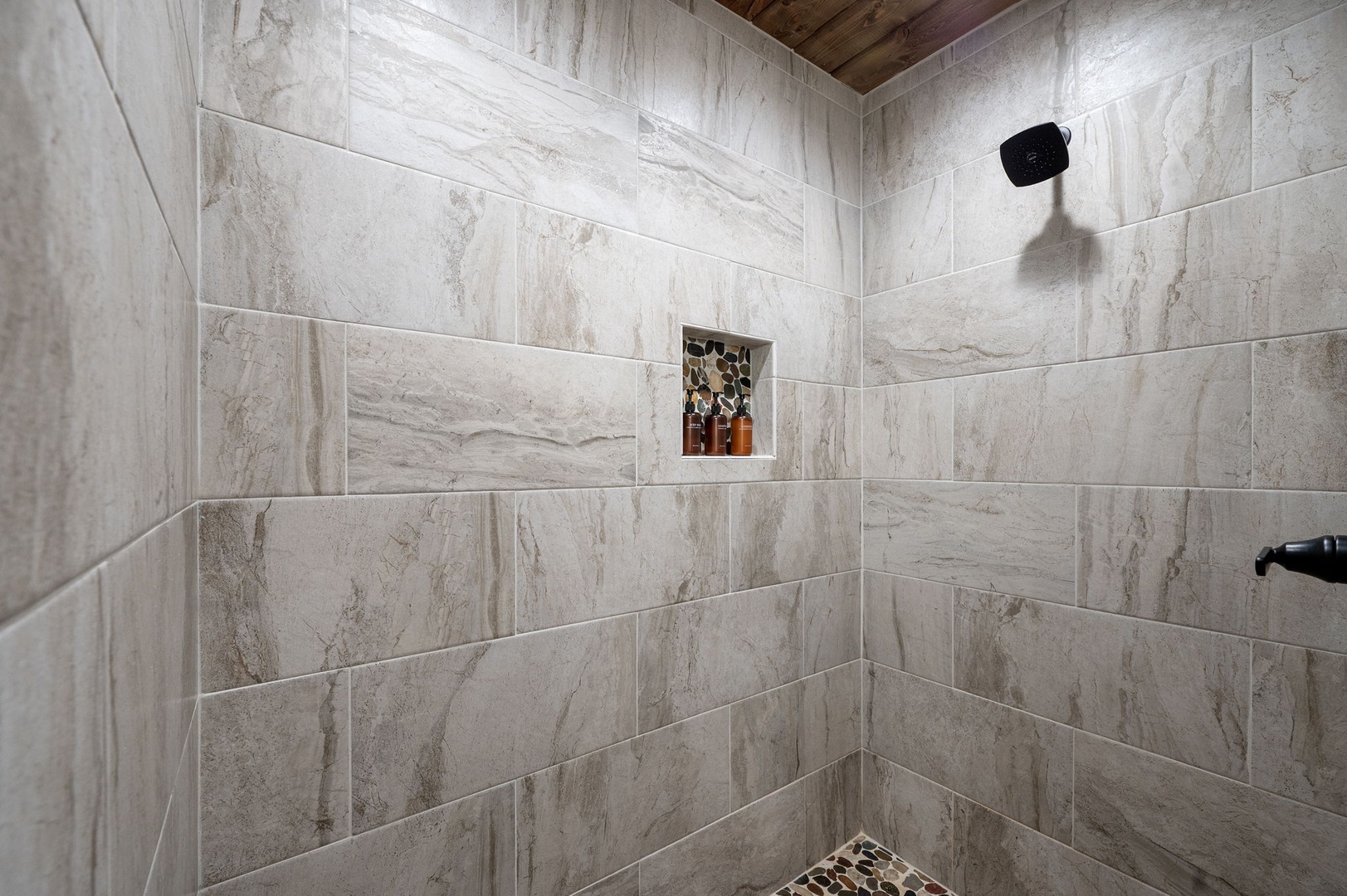 Step into your private spa-like shower with elegant marble-look tile, a sleek matte-black rainfall showerhead, and thoughtful built-in niche for your toiletries—designed for pure relaxation.