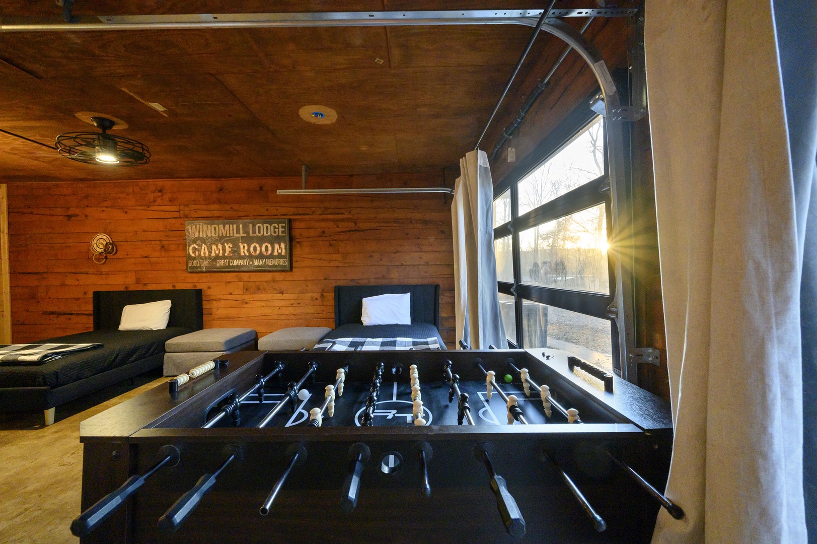 Challenge friends to foosball in this cozy game room, where warm wood paneling and comfortable seating create the perfect space for friendly competition.