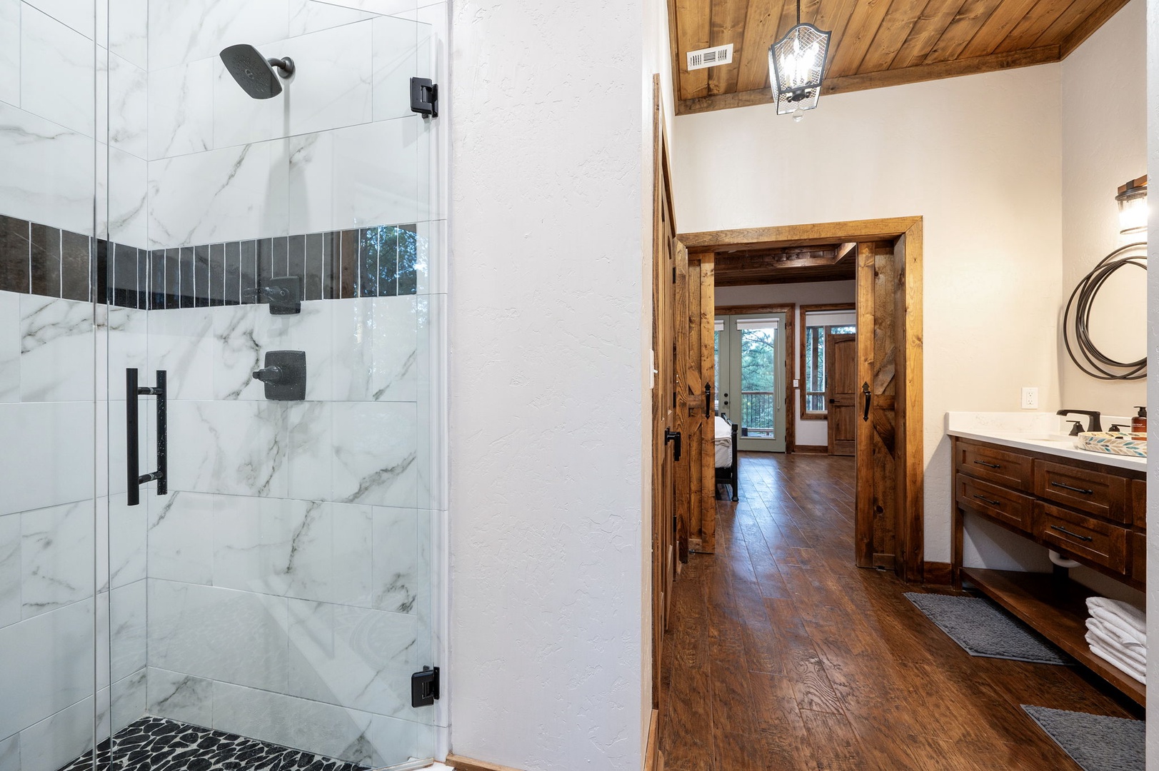 Indulge in your private spa-inspired retreat, where elegant marble tiles and sleek fixtures meet warm wood details. Refresh in the spacious walk-in shower, then step into inviting spaces designed for your comfort.