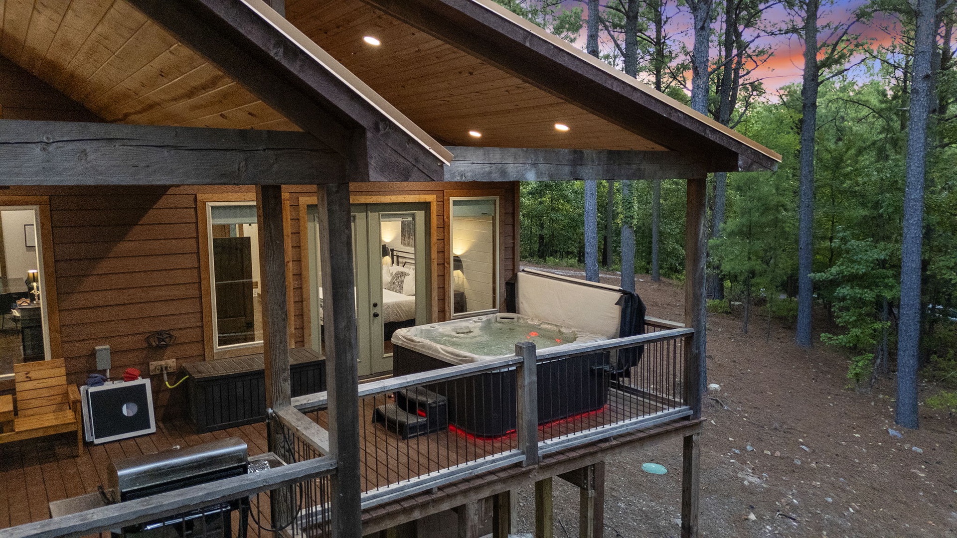 Unwind in your private hot tub under a wooden pergola as the sun sets over towering pines. This elevated deck space invites you to soak, relax, and breathe in the natural beauty surrounding you.