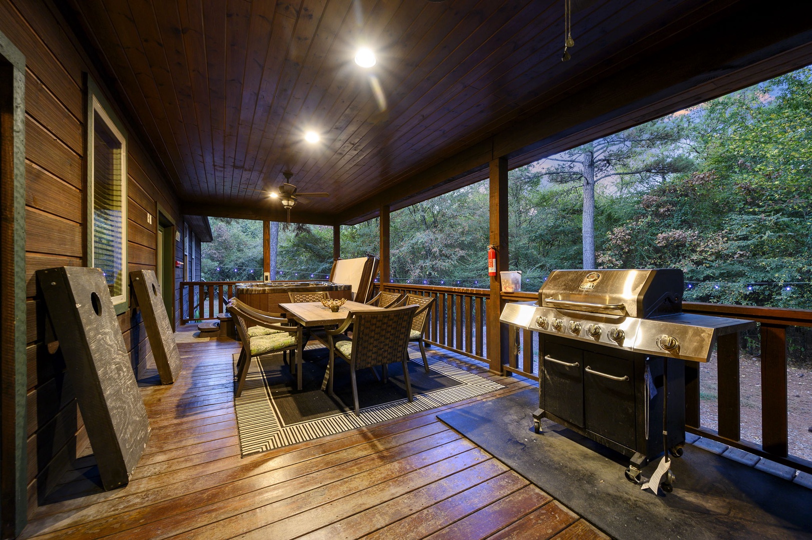 Step onto your private screened porch where twilight gatherings come alive around the grill. Surrounded by forest views and warm wood details, you'll enjoy peaceful evenings cooking and dining under soft lighting.