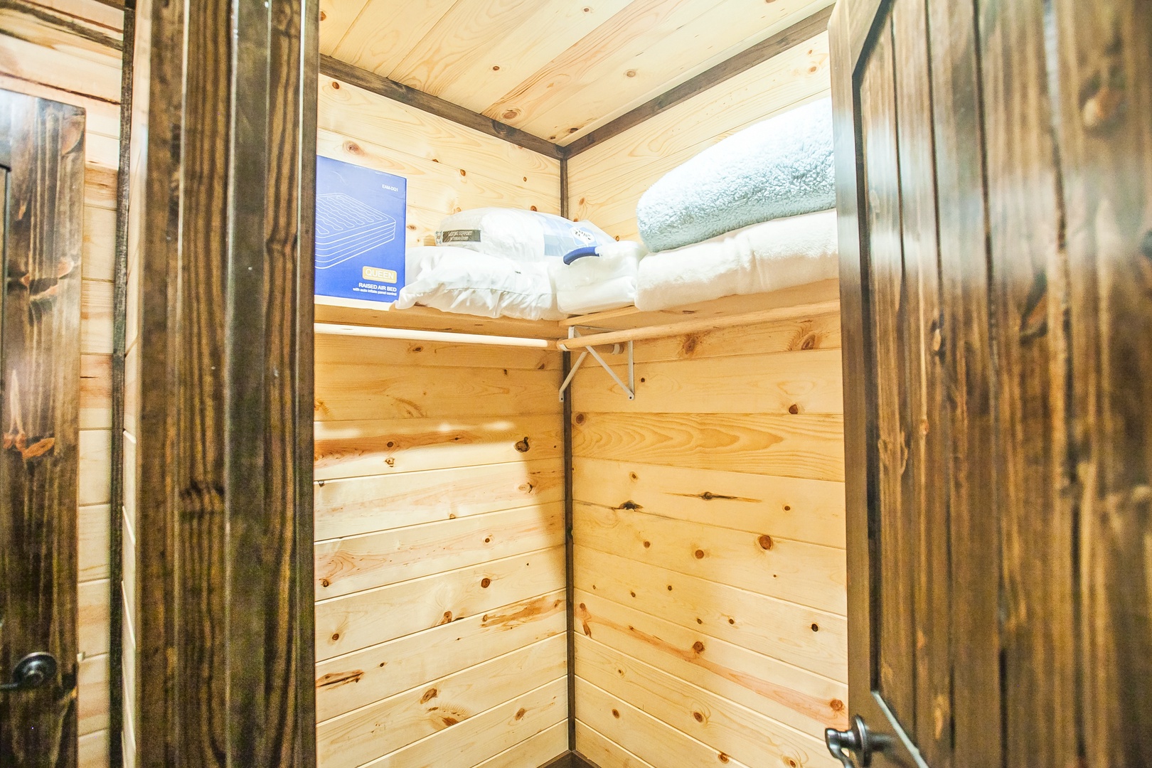 Your cozy wooden closet offers plenty of storage space with fresh linens and thoughtful touches for your mountain getaway.