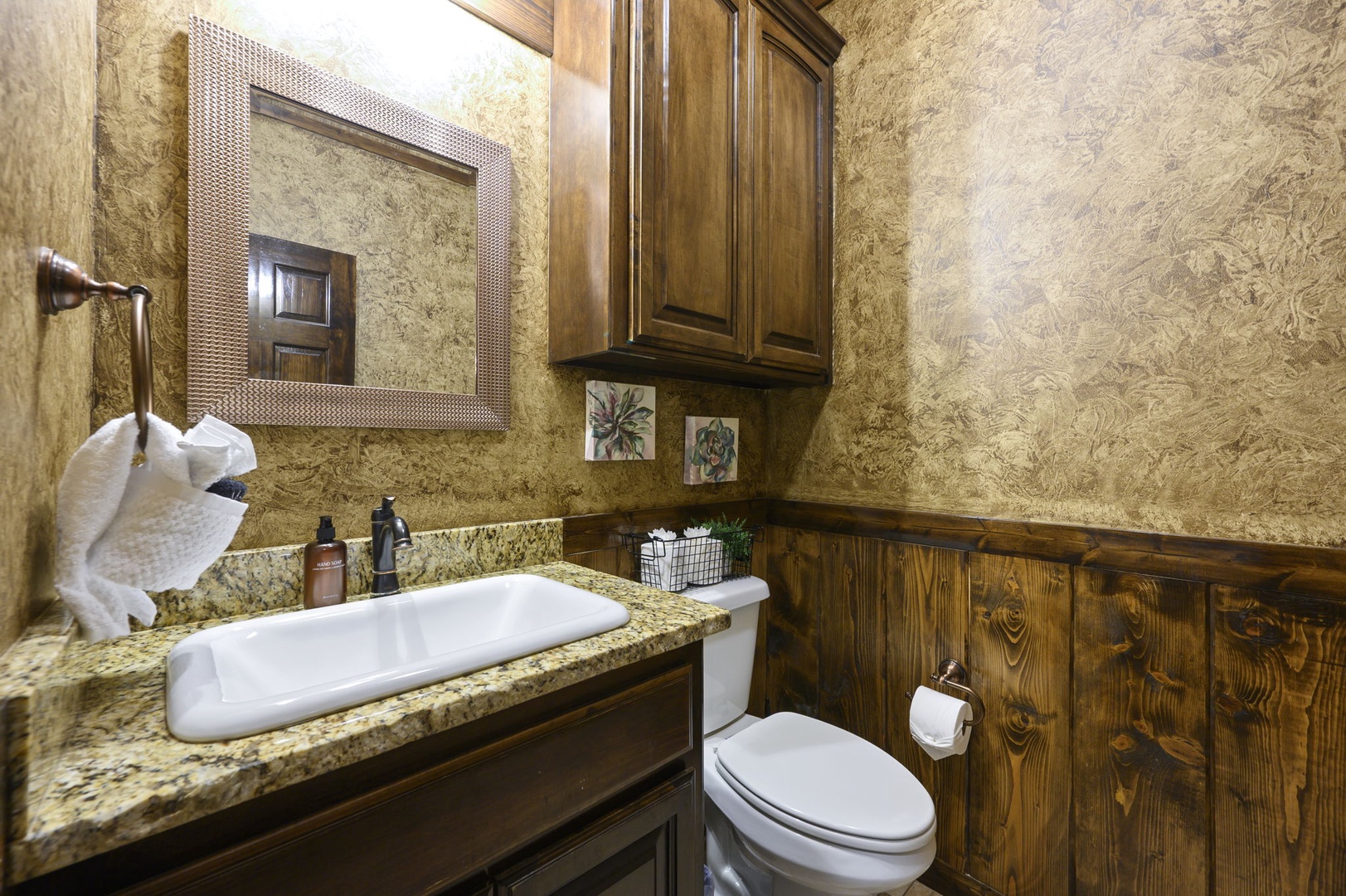 Step into your private bathroom, where warm wood tones and granite surfaces create a rustic yet refined retreat perfect for unwinding after a day of adventure.