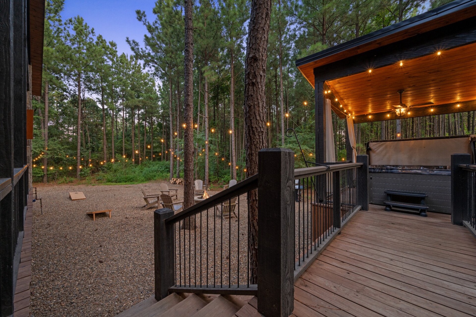 Gather under twinkling string lights in your private wooded sanctuary, where a spacious deck with hot tub awaits and a fire pit beckons you to unwind beneath towering pines.