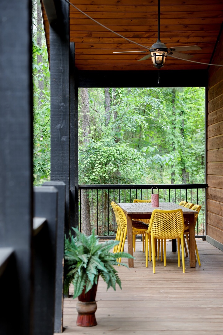 Covered outdoor dining area with peaceful wooded views, offering a relaxing spot to enjoy meals together.