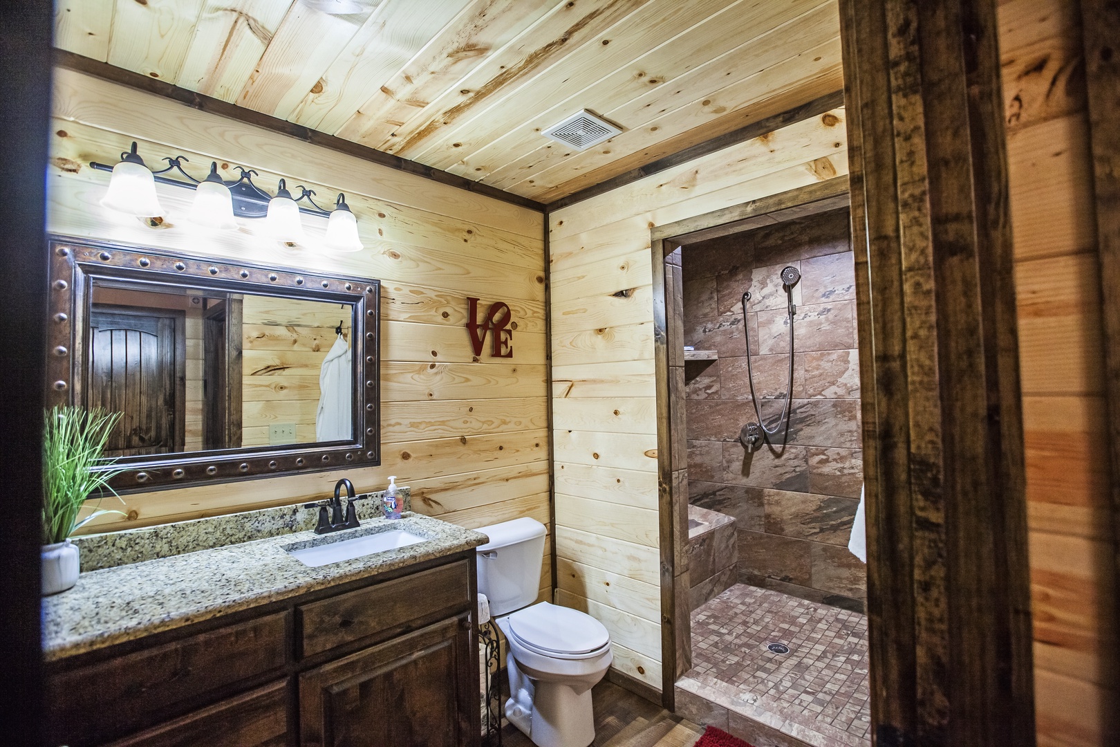 Unwind in your rustic bathroom with stone shower and warm wood accents creating the perfect mountain retreat ambiance.