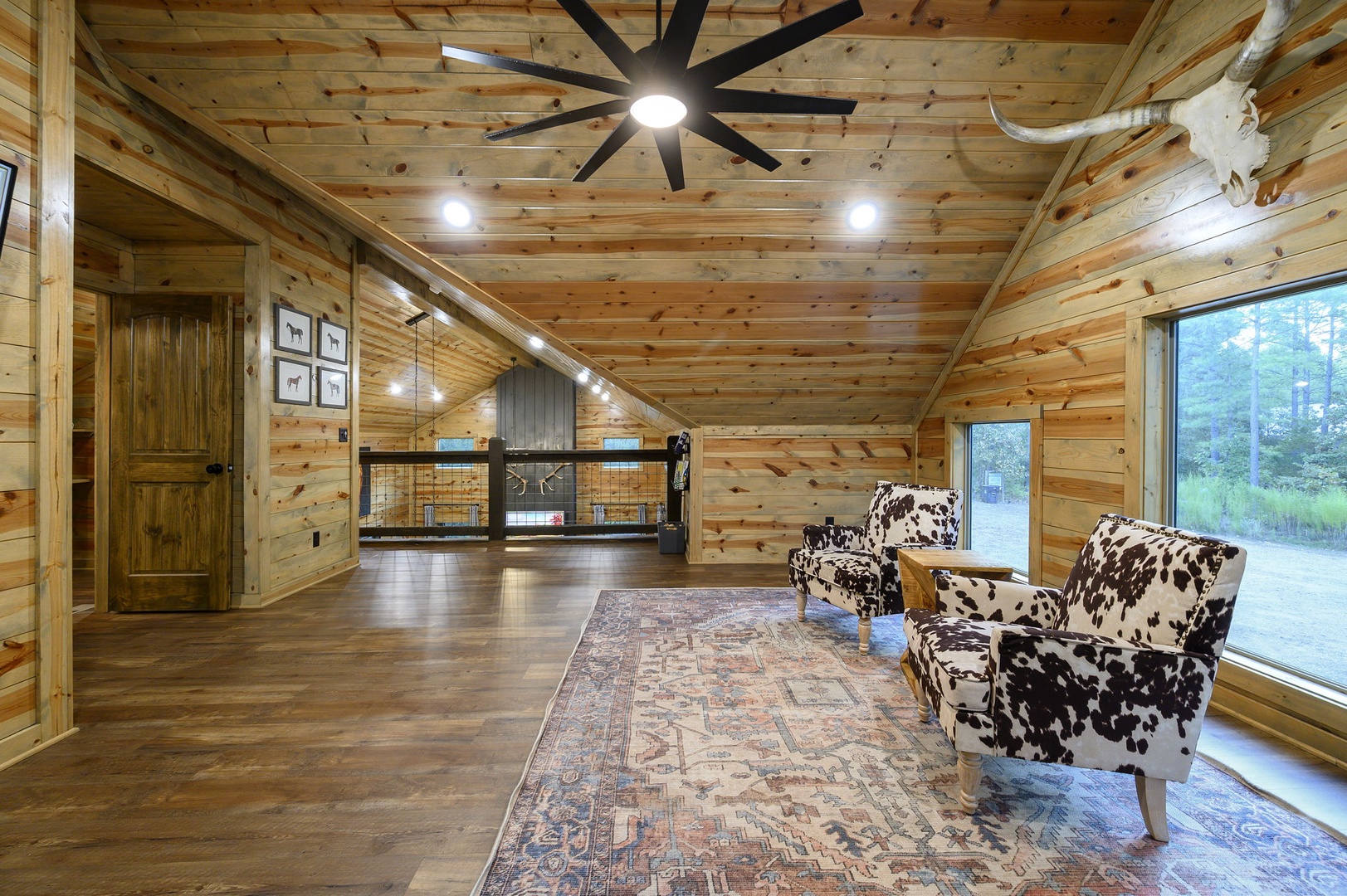 Step into rustic charm with soaring wood-beamed ceilings, cozy cowhide chairs, and views of the surrounding countryside—your peaceful retreat awaits.