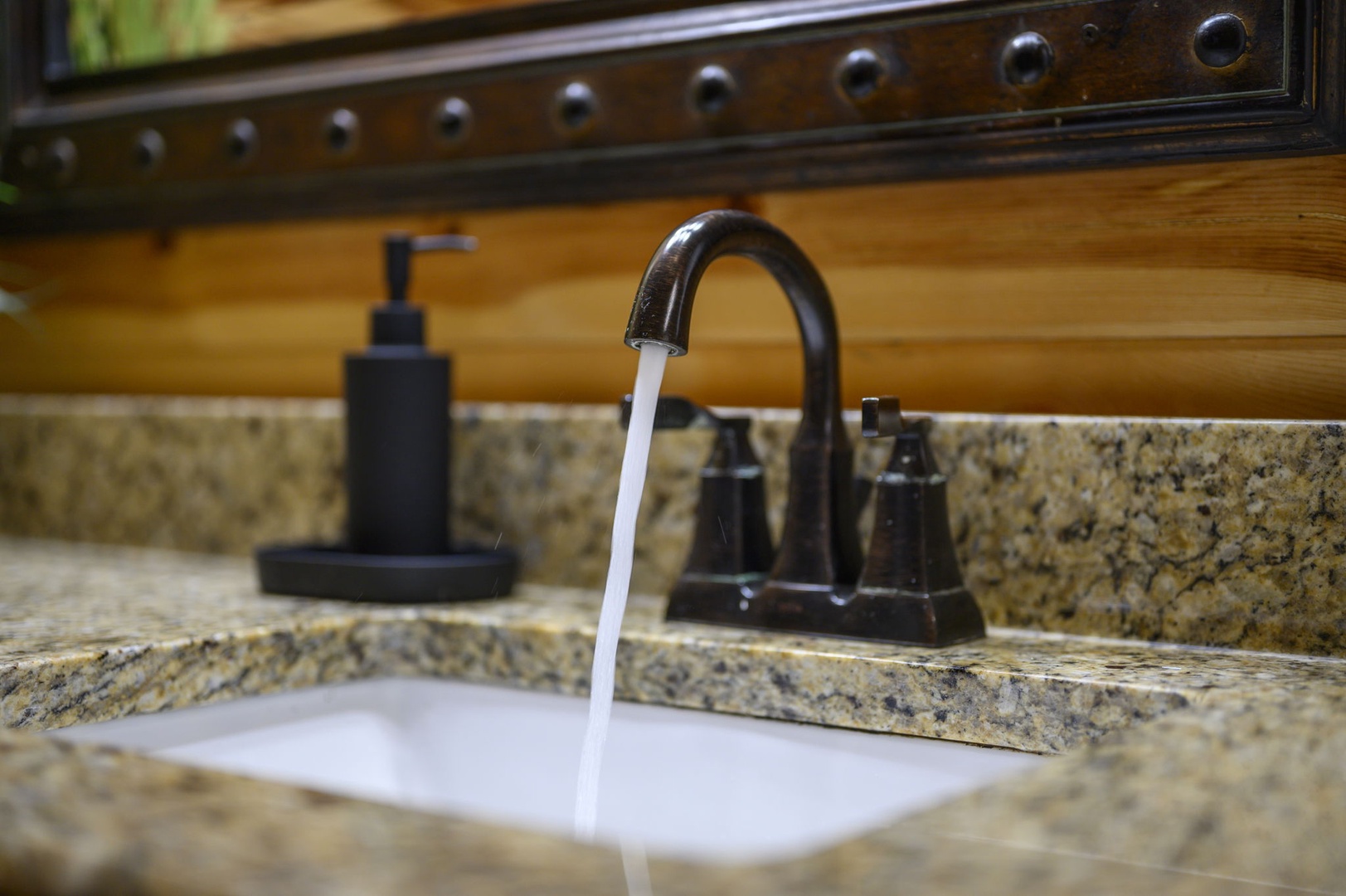 Refresh yourself at your private vanity with its elegant granite countertop, stylish bronze fixtures, and thoughtful touches like a convenient soap dispenser to make your daily routine feel effortless.
