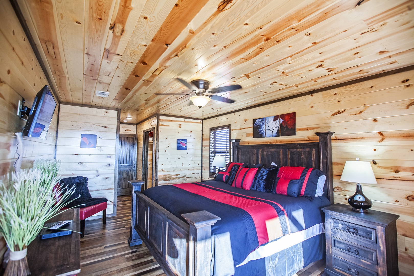 Unwind in this rustic bedroom where knotty pine walls and ceiling fan create your cozy mountain retreat.