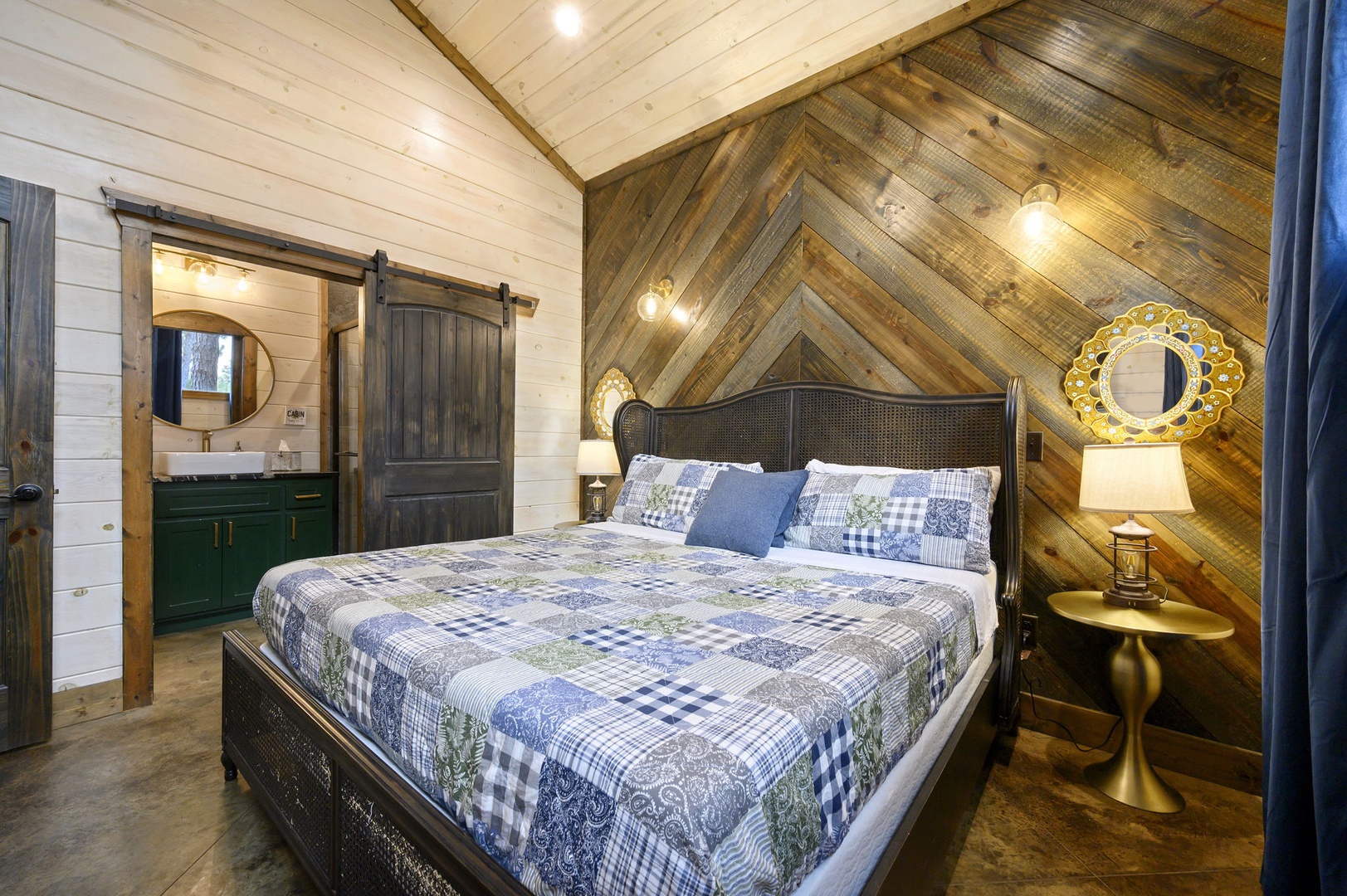 Unwind in your cozy retreat with stunning chevron wood accent walls, a plush bed dressed in soft linens, and a charming barn door leading to your private en-suite.