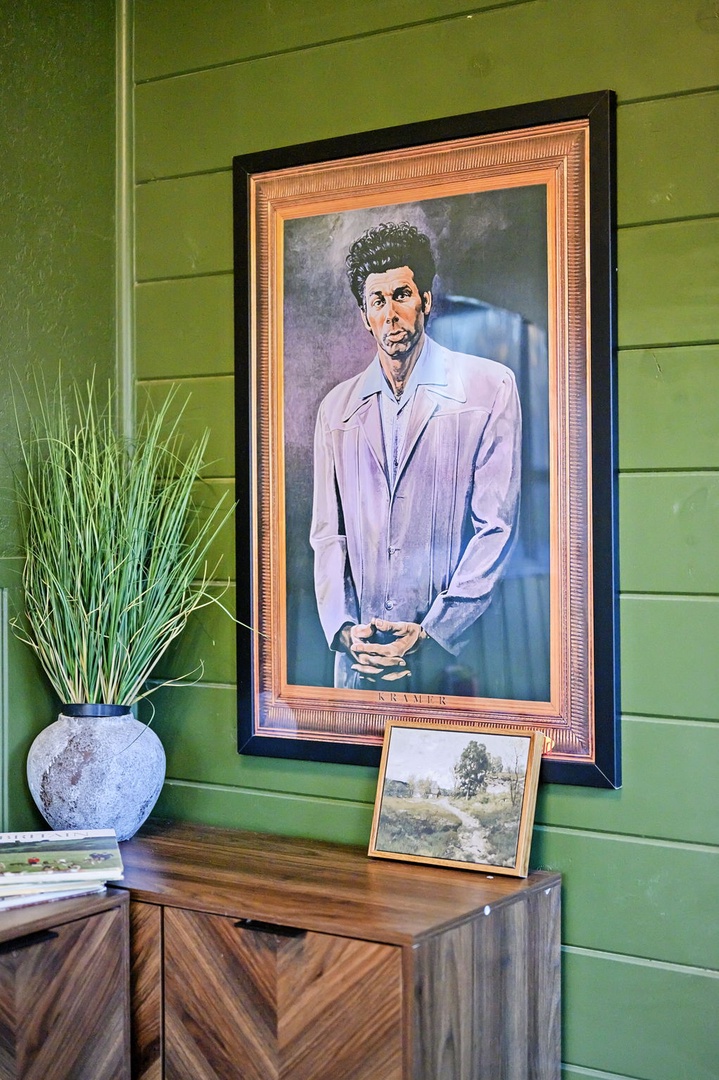 Relax in this thoughtfully curated living space, where vibrant green walls showcase captivating artwork and add character to your stay.