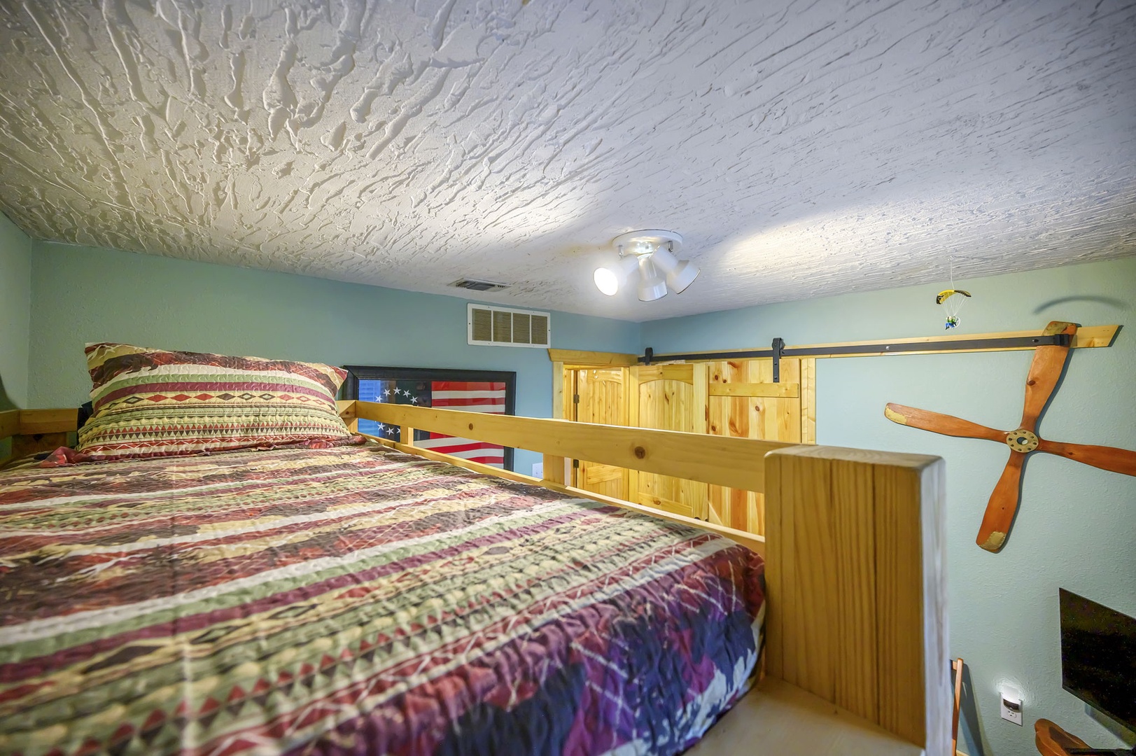 Your cozy loft bedroom features rustic wooden details and unique ceiling textures, creating a charming retreat for peaceful nights.
