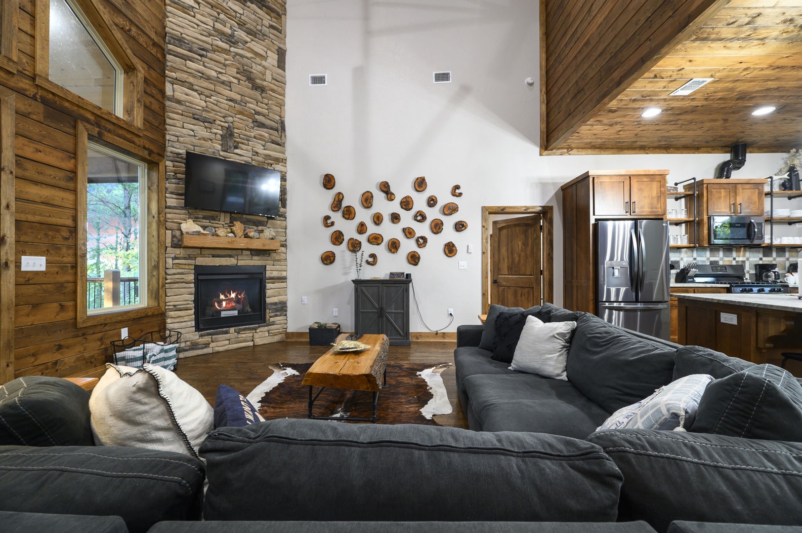 Sink into plush sofas beside a crackling fireplace, surrounded by warm wood and soaring ceilings. Your open-concept retreat blends rustic charm with modern comforts for the perfect getaway.