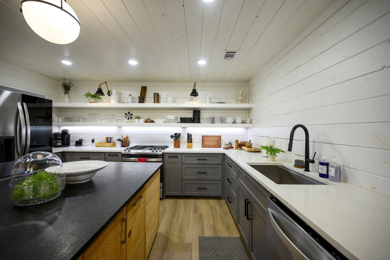 Your spacious gourmet kitchen features modern appliances, ample counter space, and open shelving for all your culinary adventures.