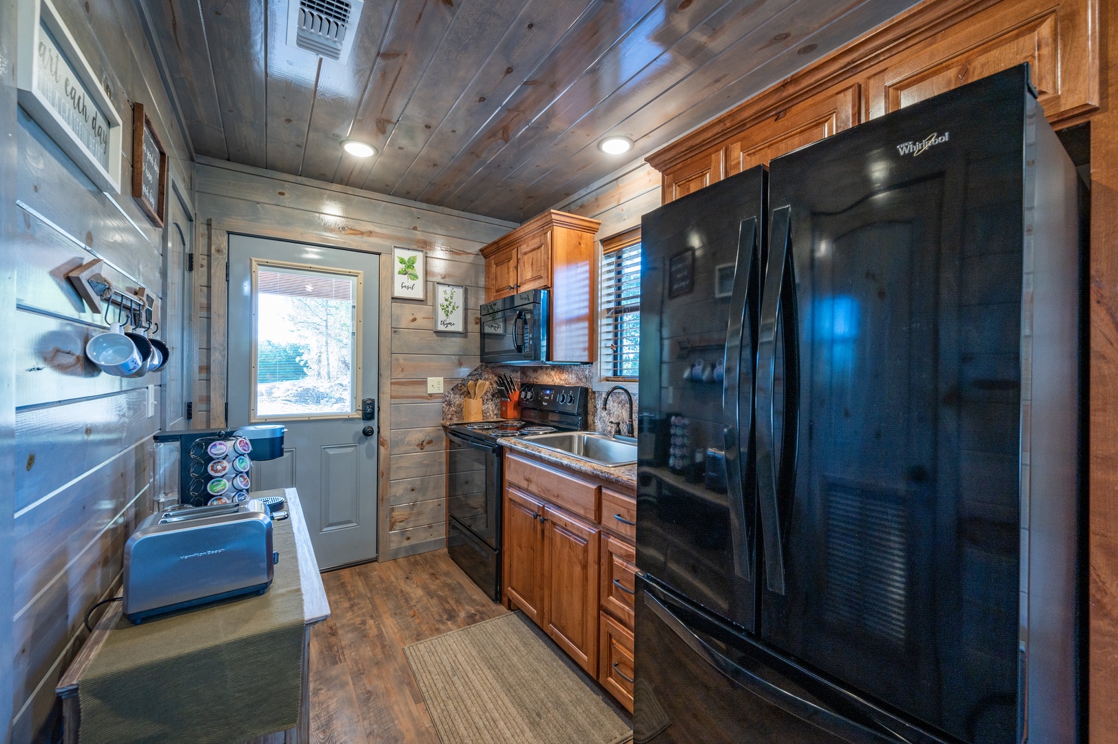Your fully equipped rustic kitchen features rich wood cabinets, modern appliances, and charming log cabin walls for memorable mountain meals.