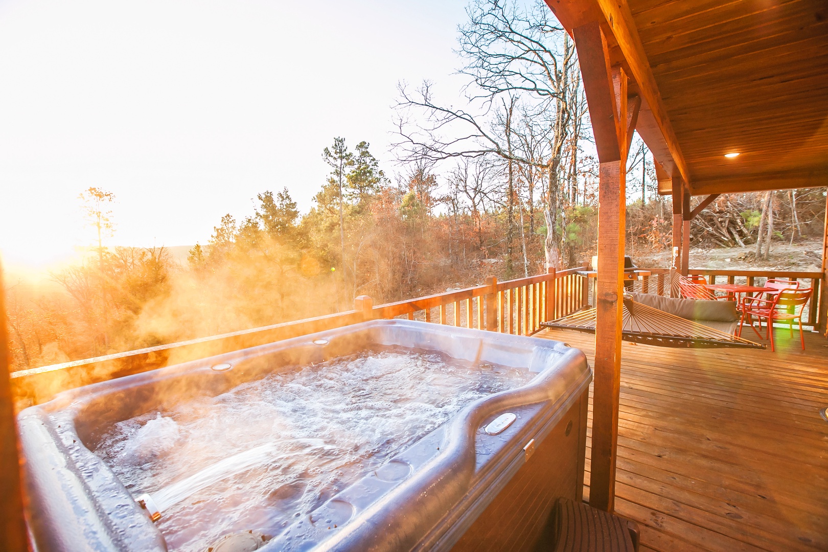 Soak in your private hot tub as golden sunrise light filters through autumn trees, creating the perfect morning retreat.