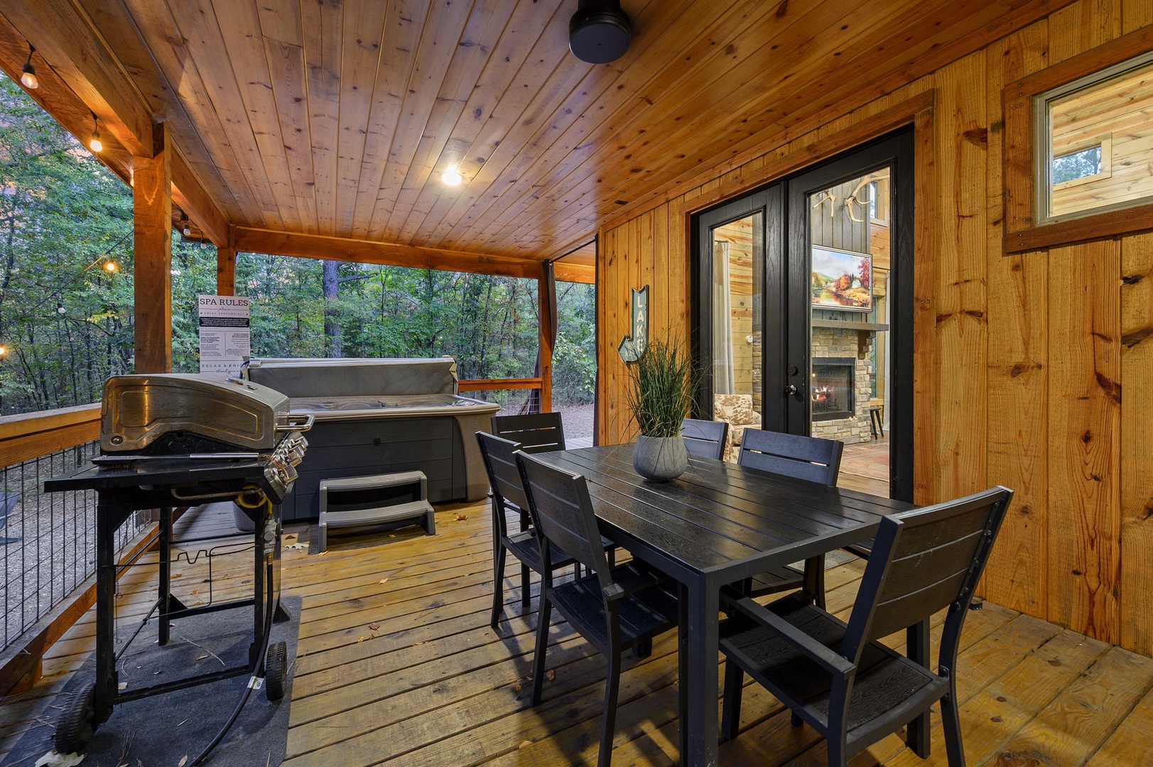 Your private covered patio invites you to dine al fresco surrounded by forest views, with a hot tub and BBQ grill just steps away for the perfect evening retreat.