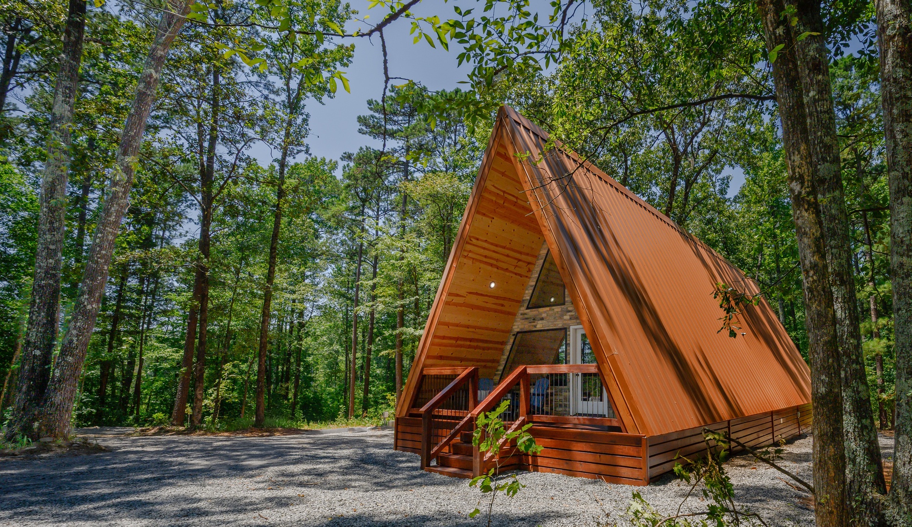 A charming A-frame cabin nestled in a peaceful forest setting, surrounded by towering trees and natural beauty—a secluded retreat where the outdoors becomes part of the experience.