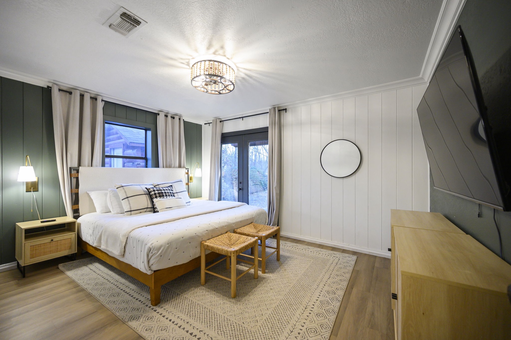 Drift off in this serene bedroom where modern comfort meets rustic charm, complete with elegant lighting and peaceful garden views.