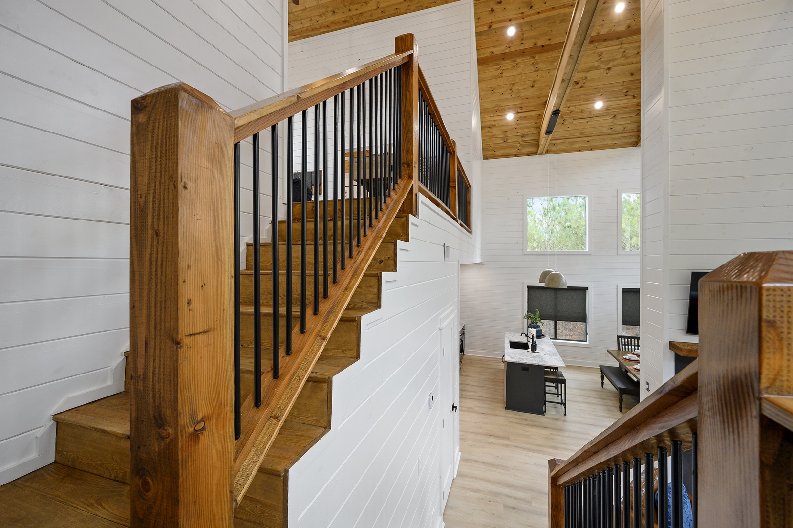 Discover your stylish retreat with beautiful wooden stairs and open living space, perfect for relaxing after mountain adventures.