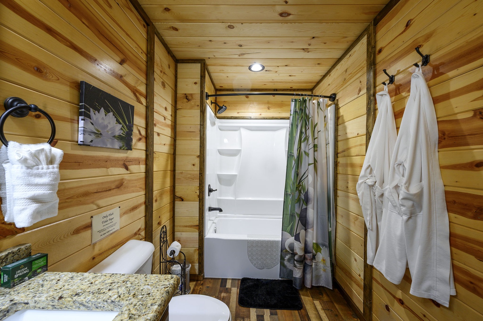 Step into your cozy cabin-style bathroom, where warm wood-planked walls create a soothing retreat. Fresh linens and plush robes await you after unwinding in the soaking tub.