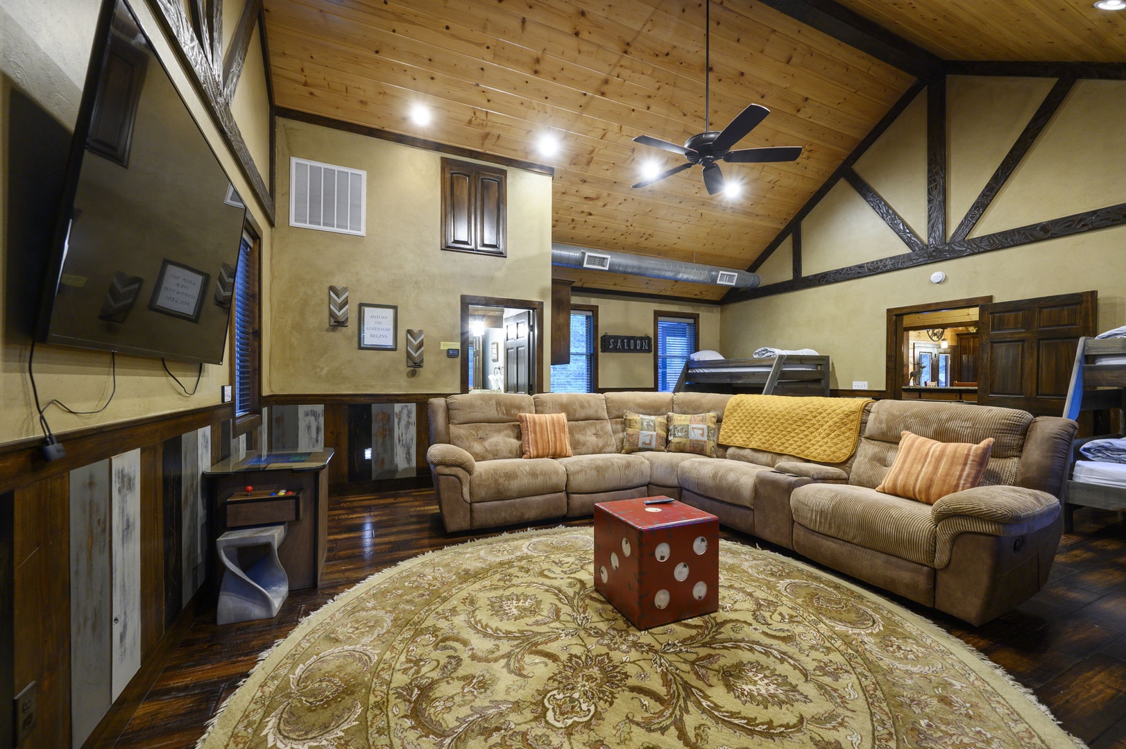 Relax under the warmth of a beautiful wood-beamed ceiling in your expansive living area. Sink into the cozy sectional and enjoy game nights at the unique dice table—this inviting space is perfect for gathering with friends and family.