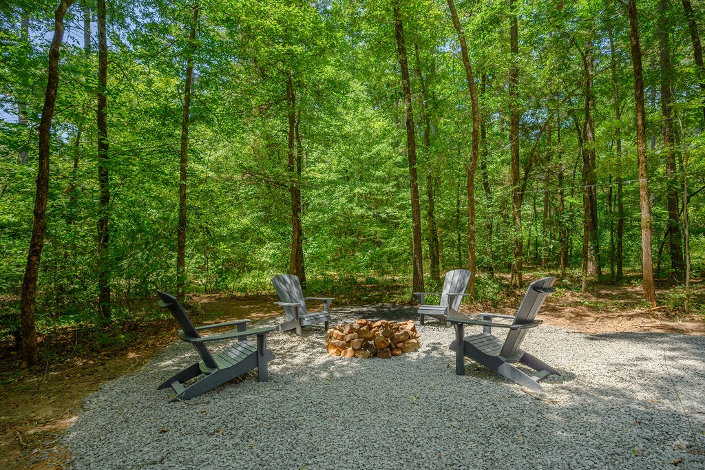 Gather around your private fire pit nestled in the trees. Four Adirondack chairs invite peaceful conversation or quiet moments while nature's canopy frames your retreat.