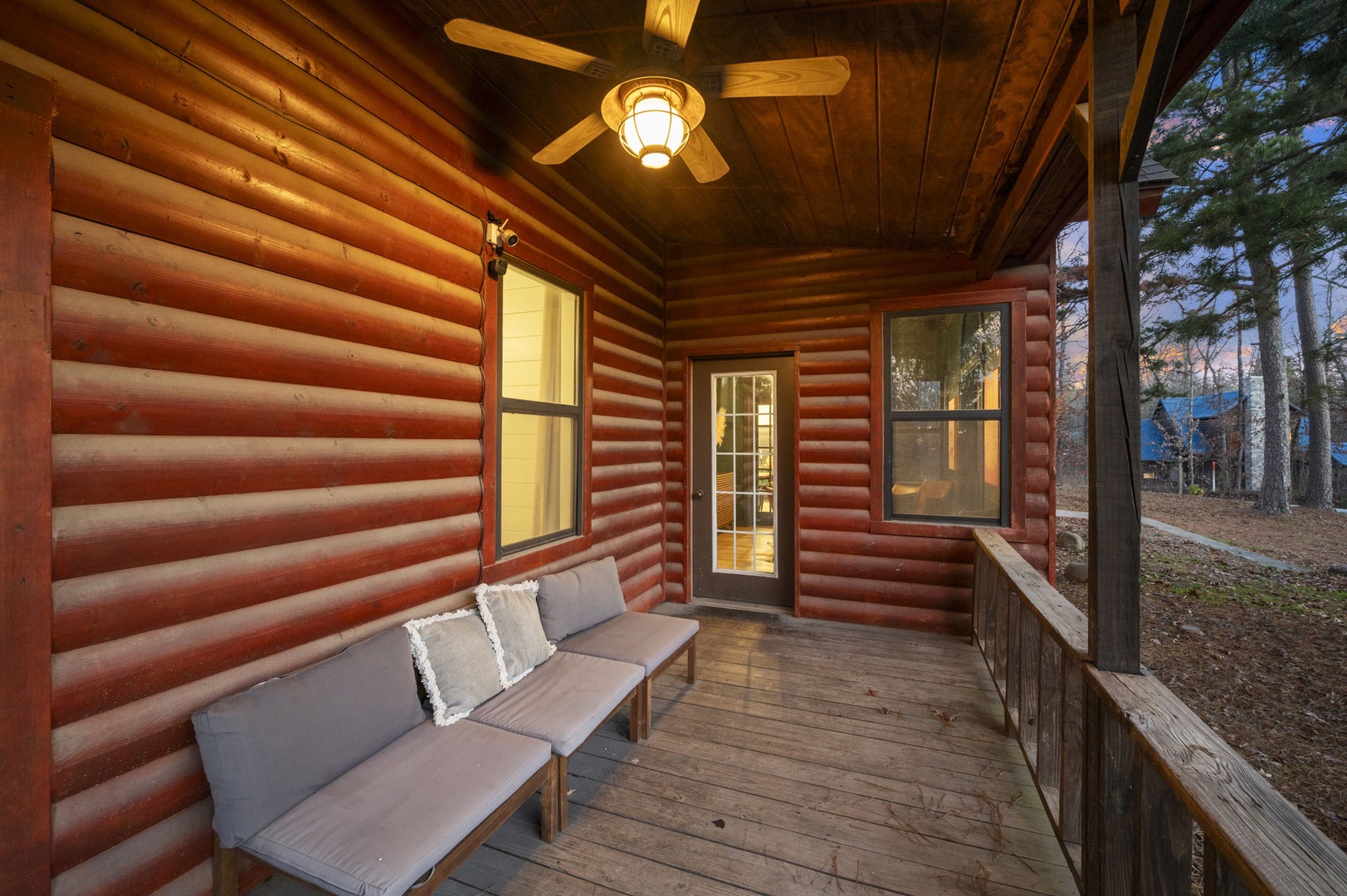 Unwind on your private screened porch with comfortable seating, where warm light and rustic charm create the perfect evening retreat.
