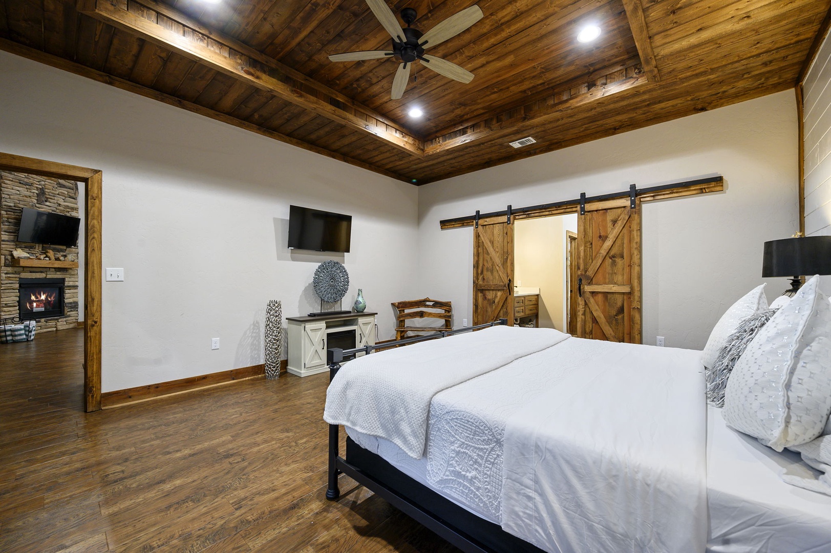 Unwind in your spacious retreat with soaring wood-beamed ceilings, charming barn doors, and a cozy fireplace. The crisp linens and peaceful ambiance invite you to settle in and truly relax.