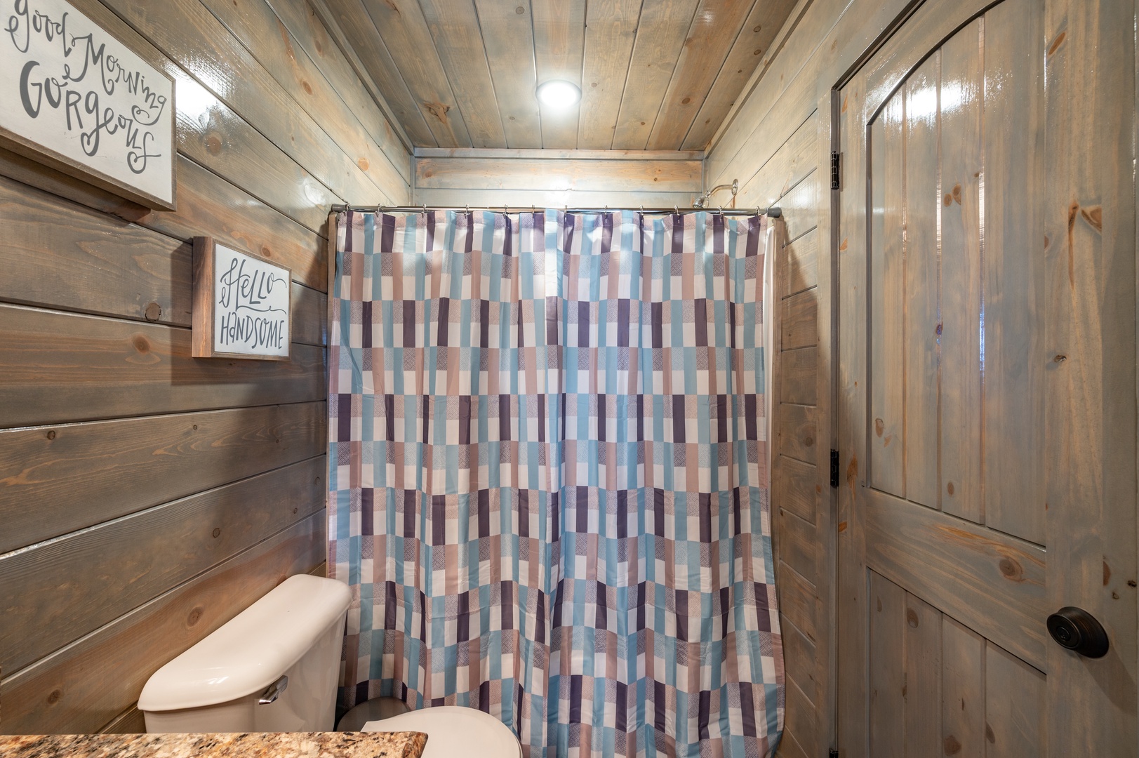 Your rustic bathroom features charming wood walls, playful décor, and a refreshing shower to rinse off after your adventures.