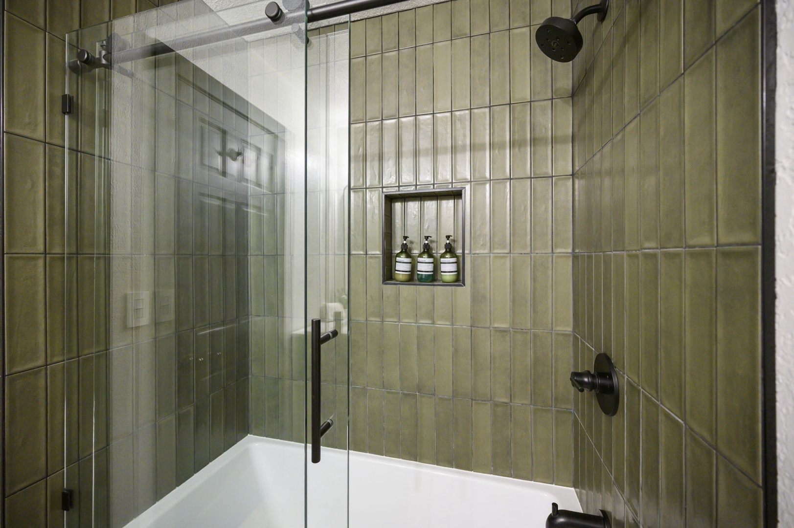 Step into your sleek glass-enclosed shower with rainfall head and premium toiletries in your modern tiled bathroom.