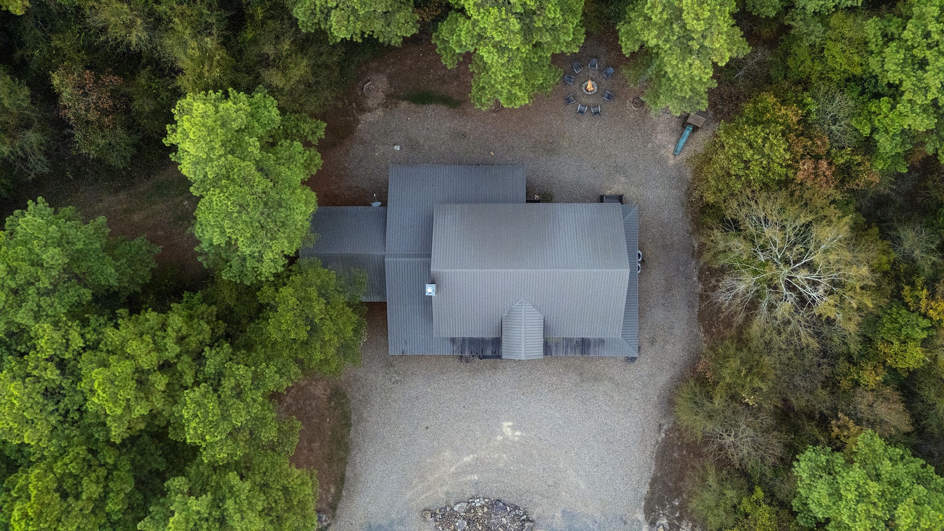 This secluded rental sits peacefully nestled within lush forest surroundings, offering a tranquil retreat with gravel grounds and private outdoor space enveloped by nature.